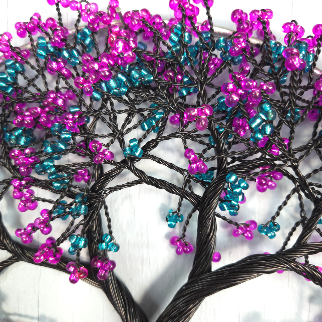 Decorative branch with pink and blue beads on a white background