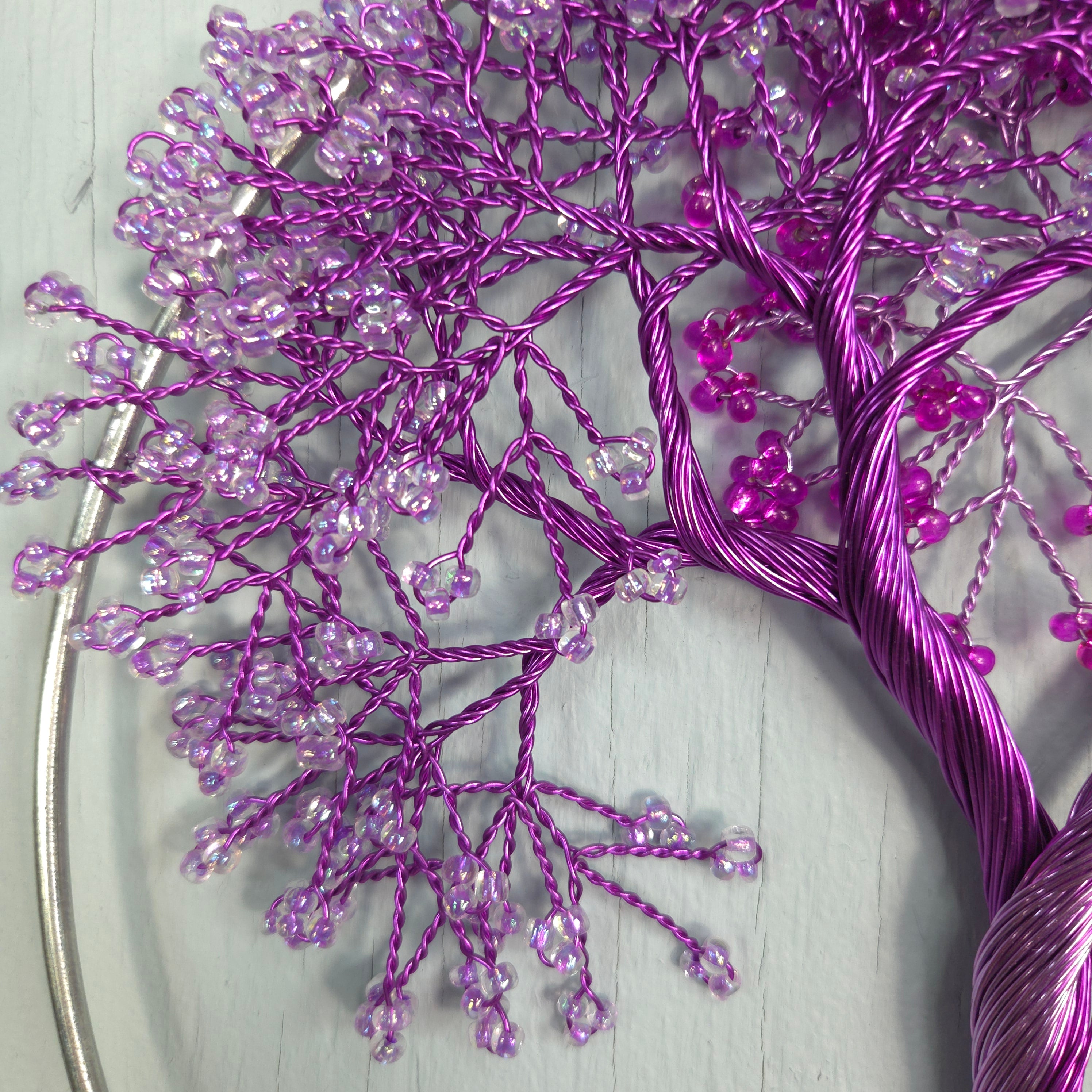 Purple beaded branch on a light gray background