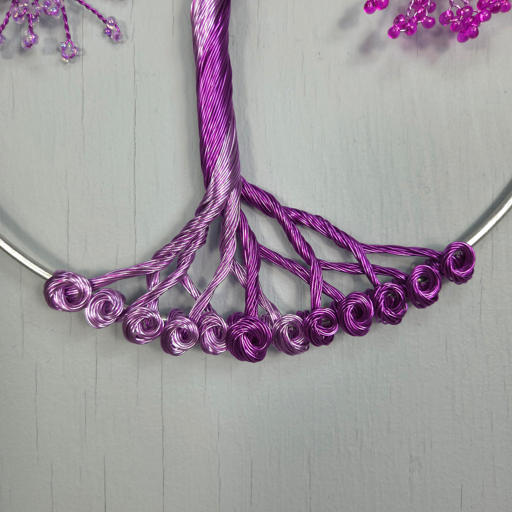 Close-up of a purple wire wreath on a gray background