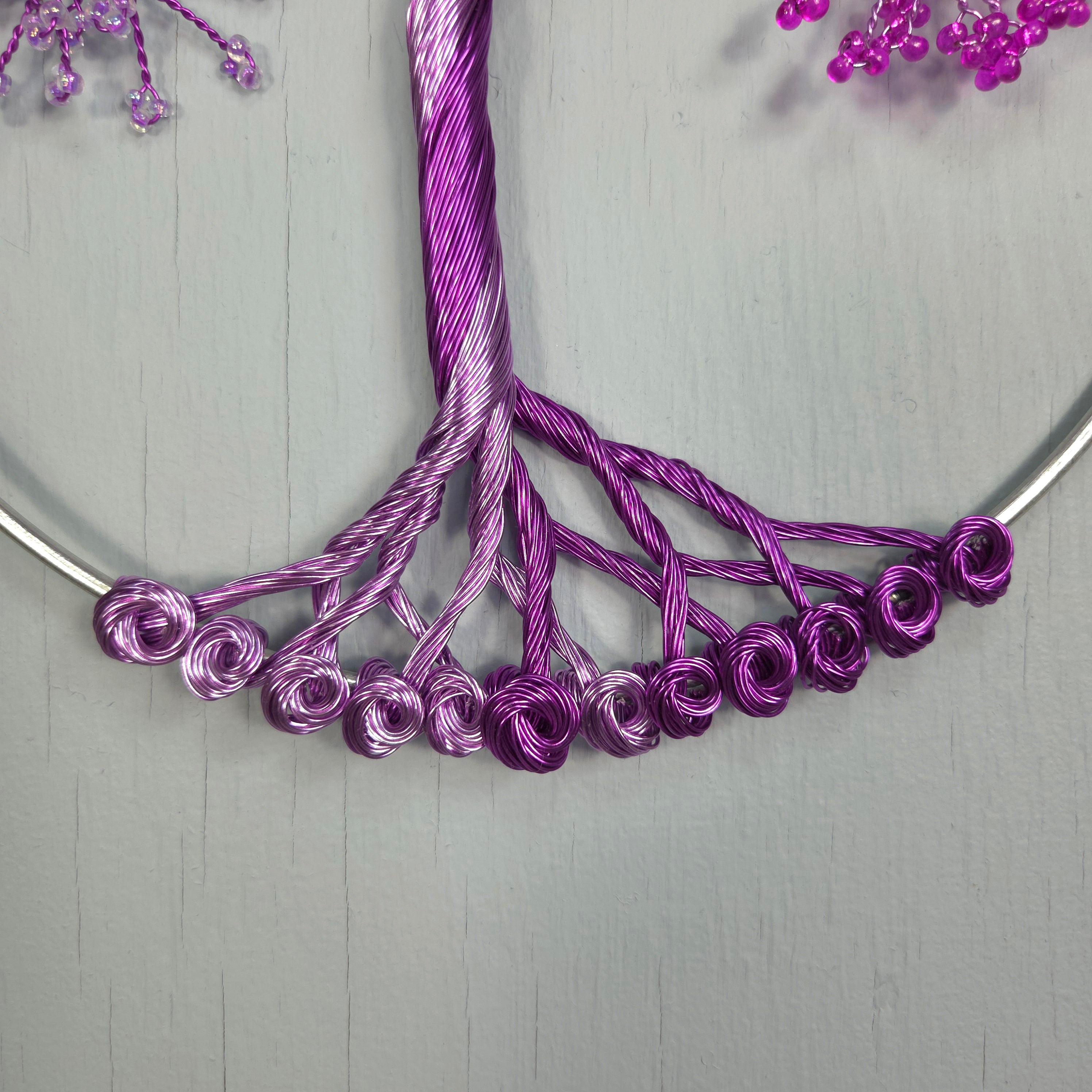 Close-up of a purple wire wreath on a gray background