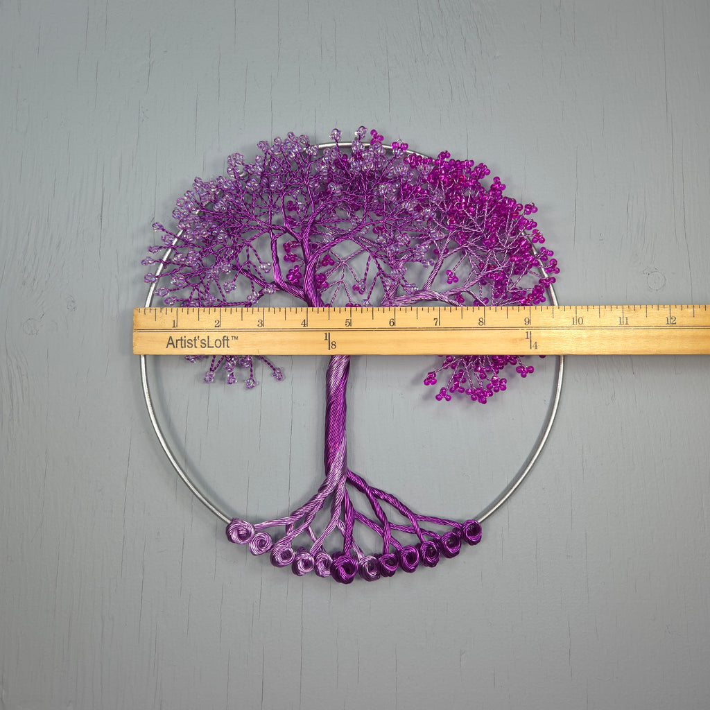 Purple tree-like decorative item with a ruler for scale on a gray background