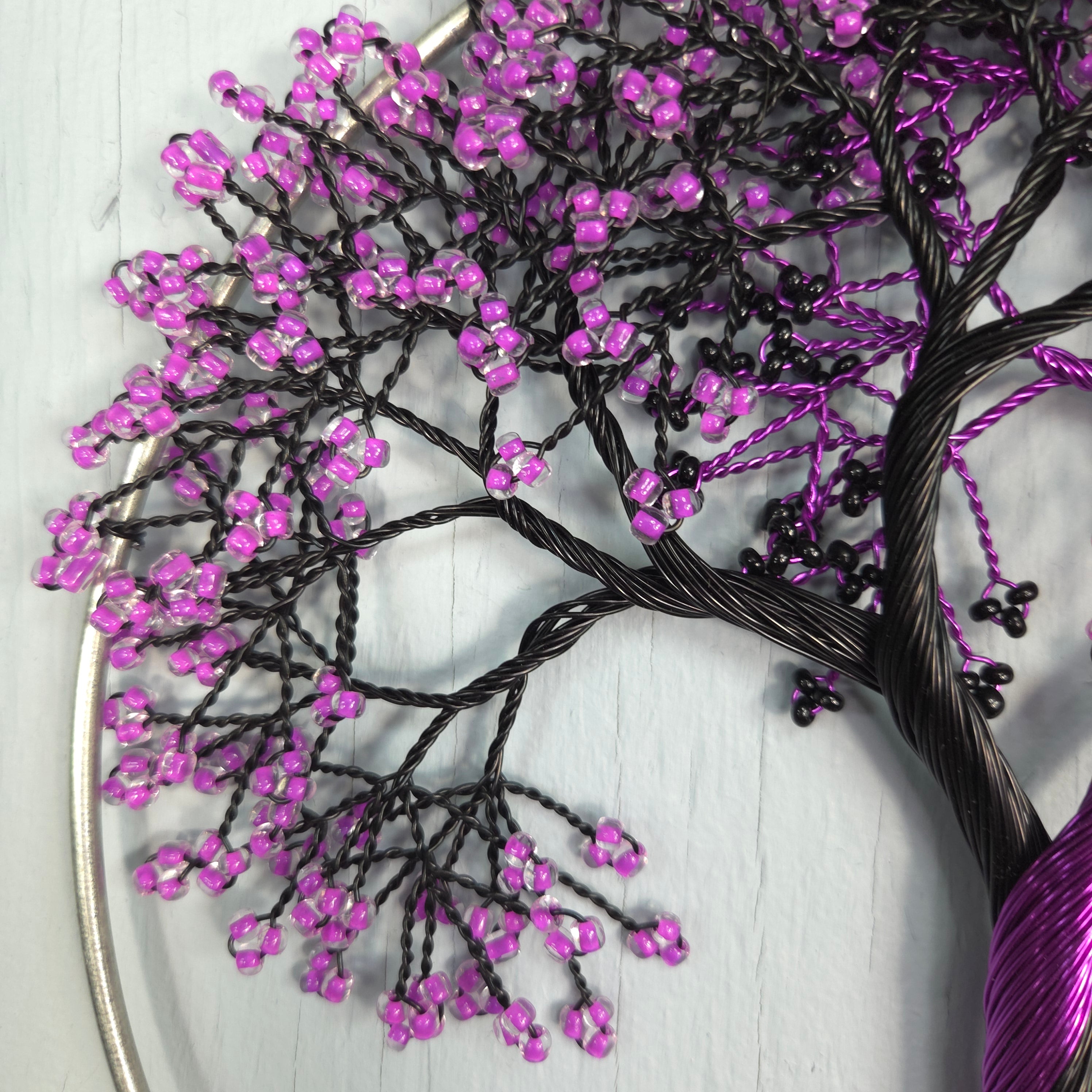 Decorative branch with purple beads on a white surface