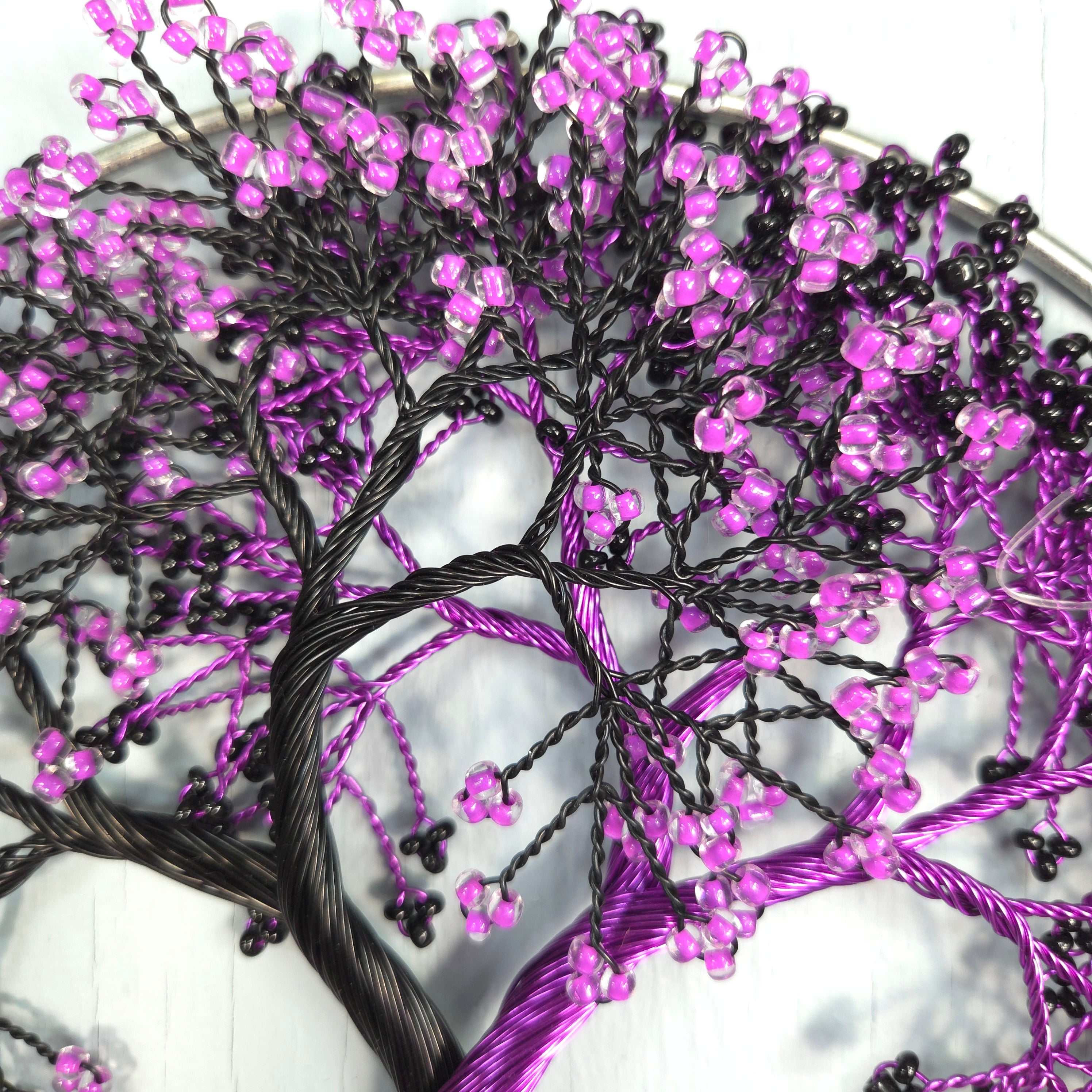 Decorative string lights with purple and black beads on a white background