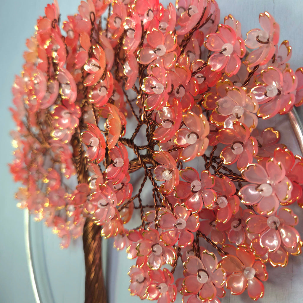 Decorative pink floral arrangement with lights against a light blue background