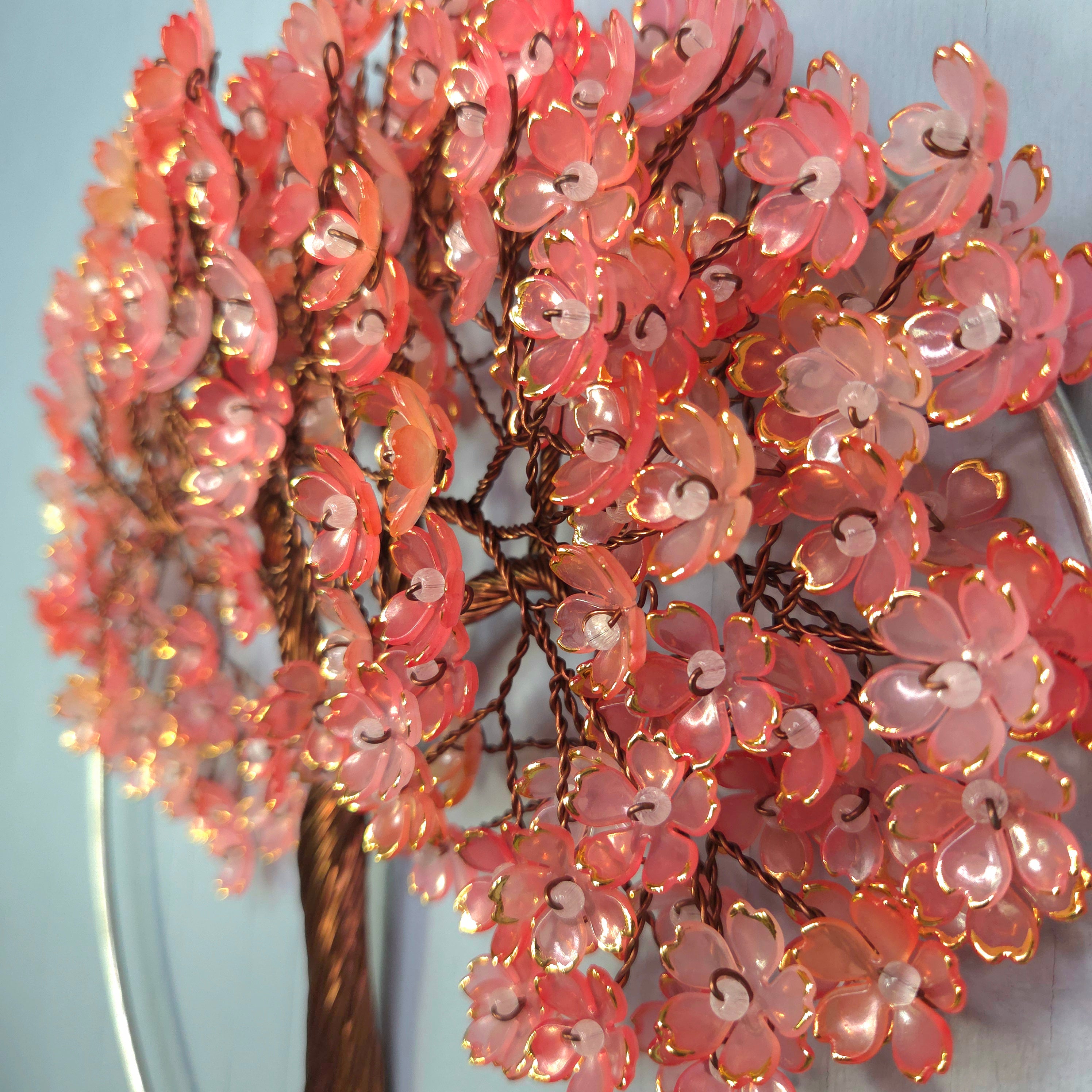 Decorative pink floral arrangement with lights against a light blue background