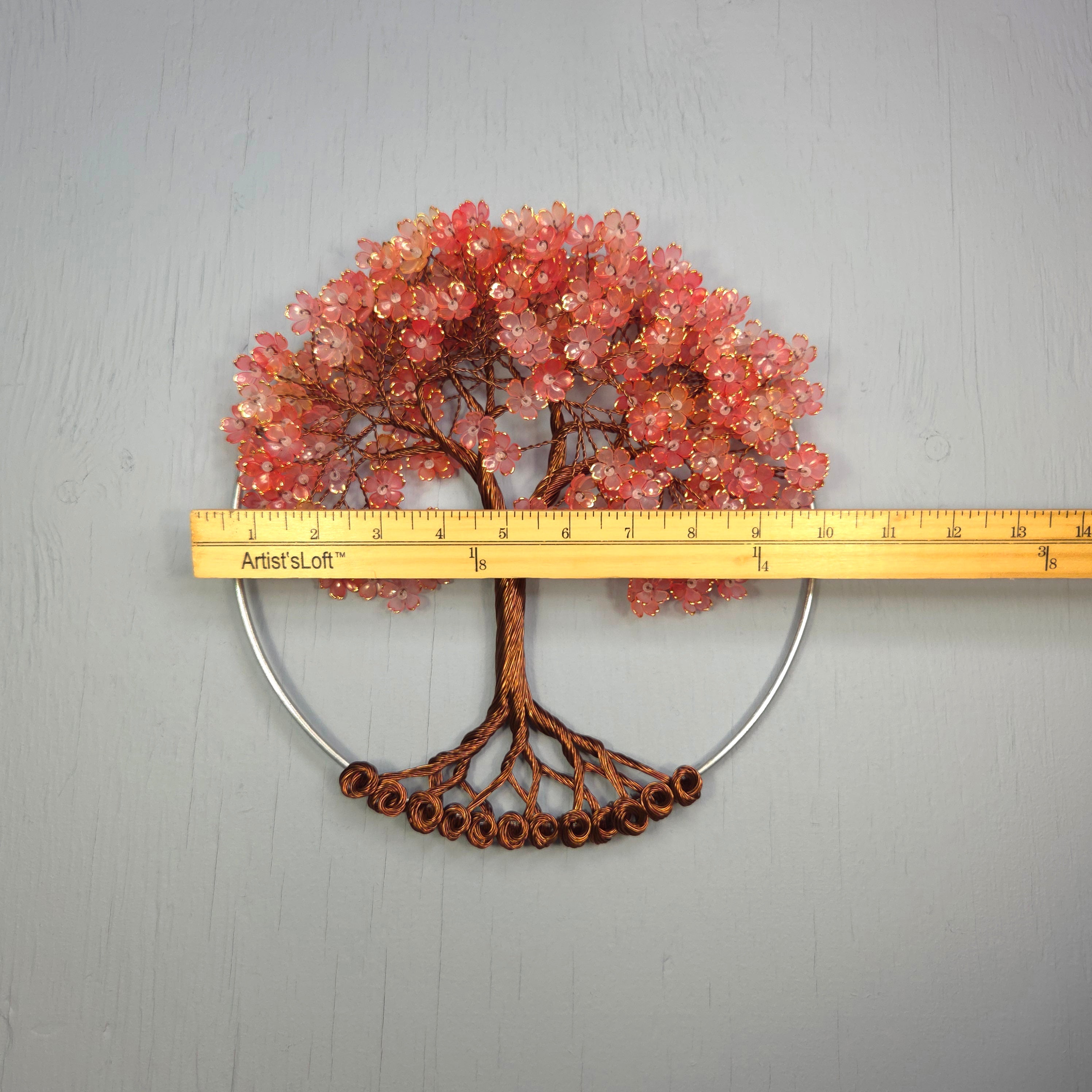 Decorative tree wall art with a ruler for scale on a gray background