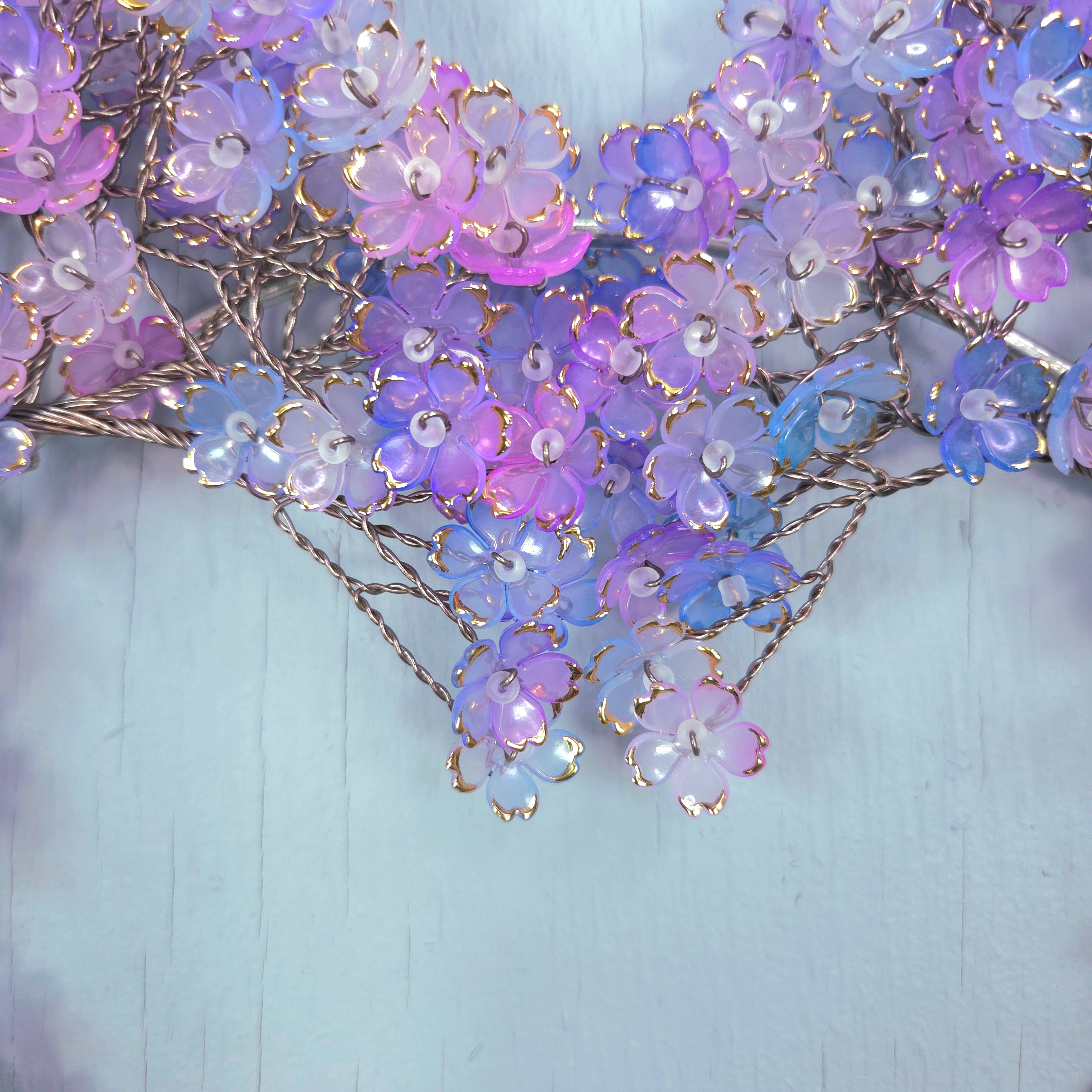 Decorative floral arrangement with purple and blue flowers on a light blue background