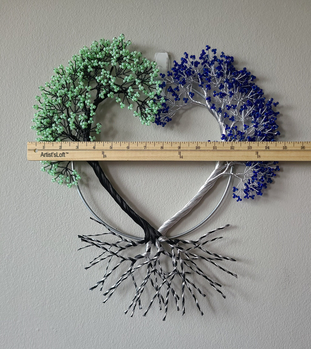 Decorative wall art with heart shape, green and blue elements, and a ruler for scale on a plain background.