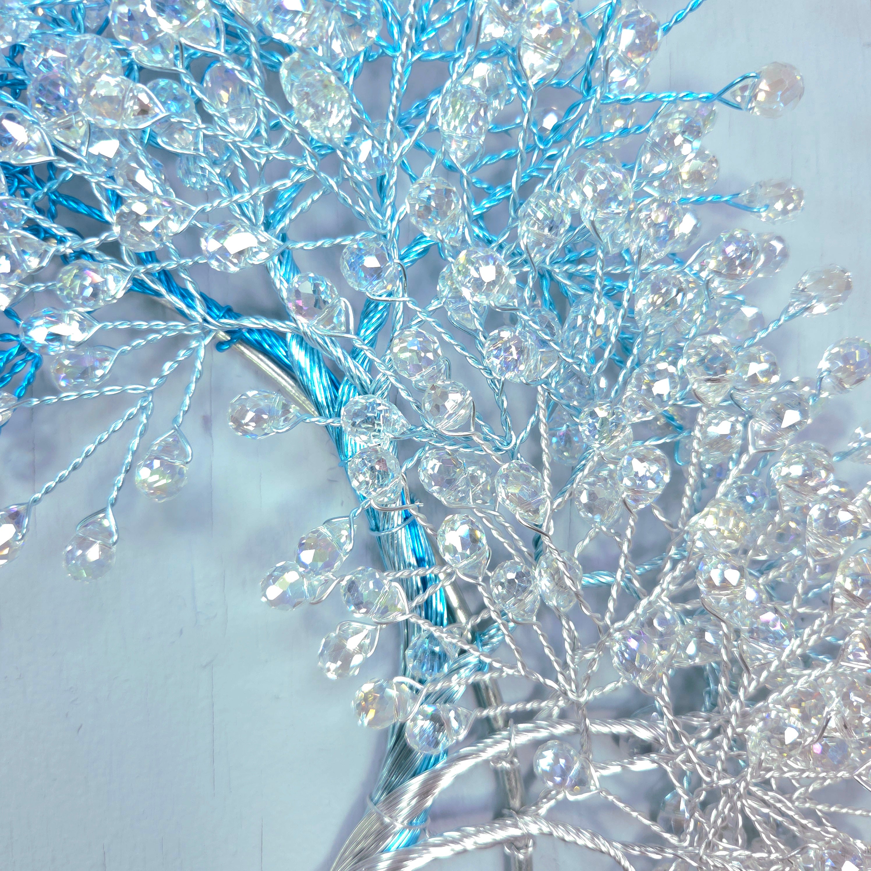 Decorative branch with blue and silver beads on a light gray background