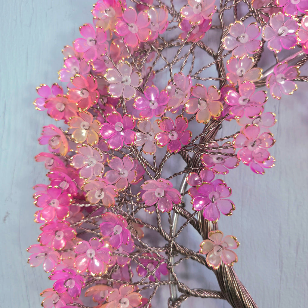 Decorative branch with pink flowers on a light blue background