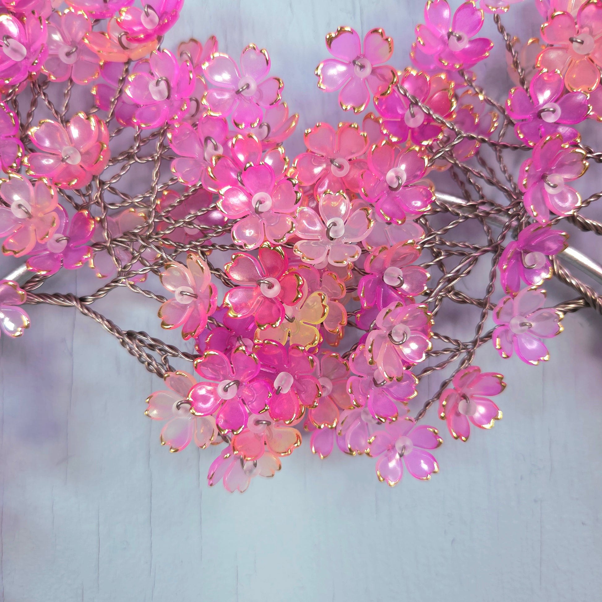 Pink artificial flowers on a light blue background