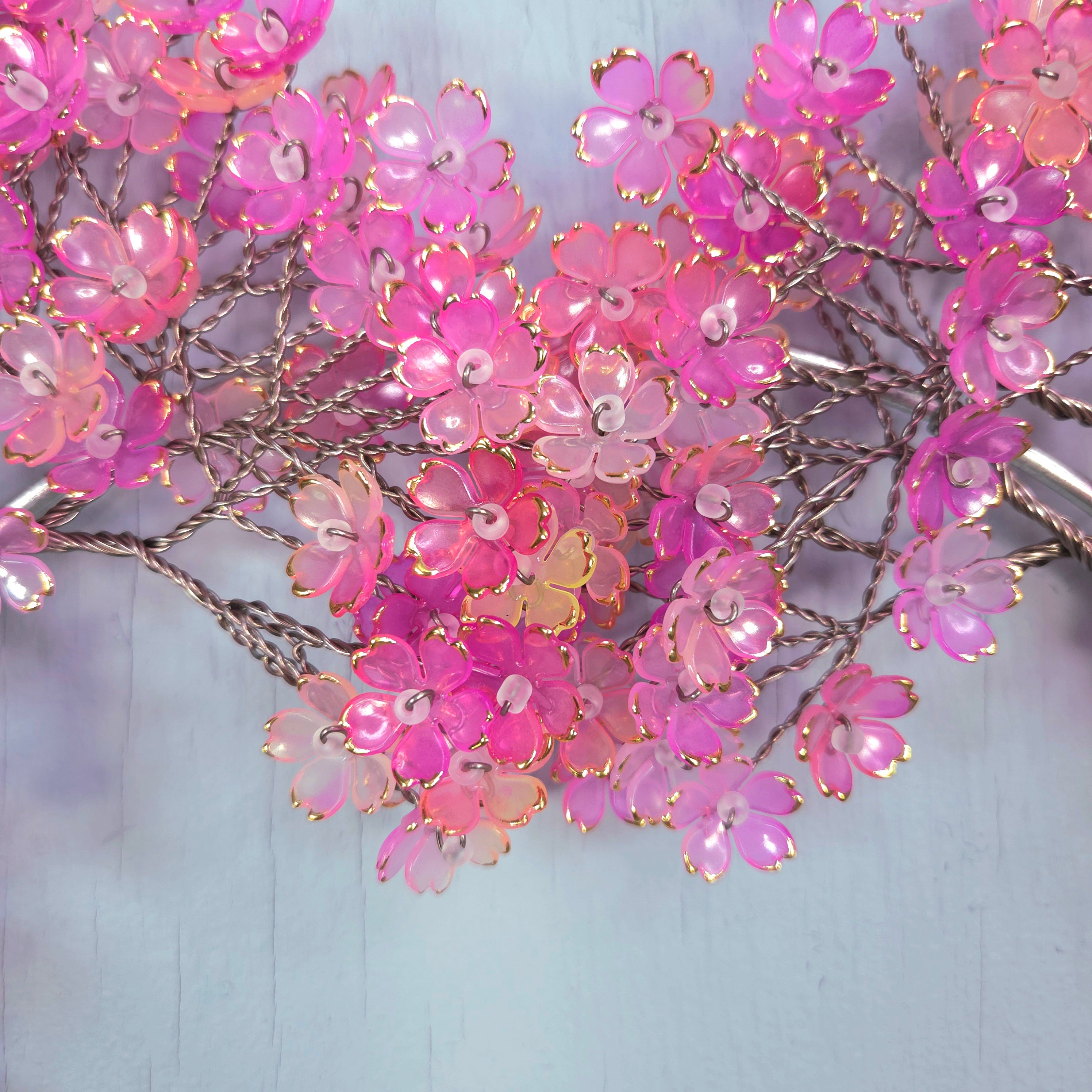 Pink artificial flowers on a light blue background