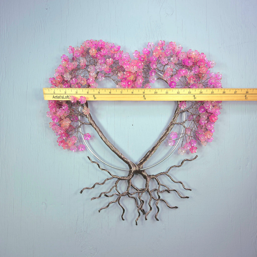 Heart-shaped decorative wall piece with pink flowers and bare branches, measured against a ruler.