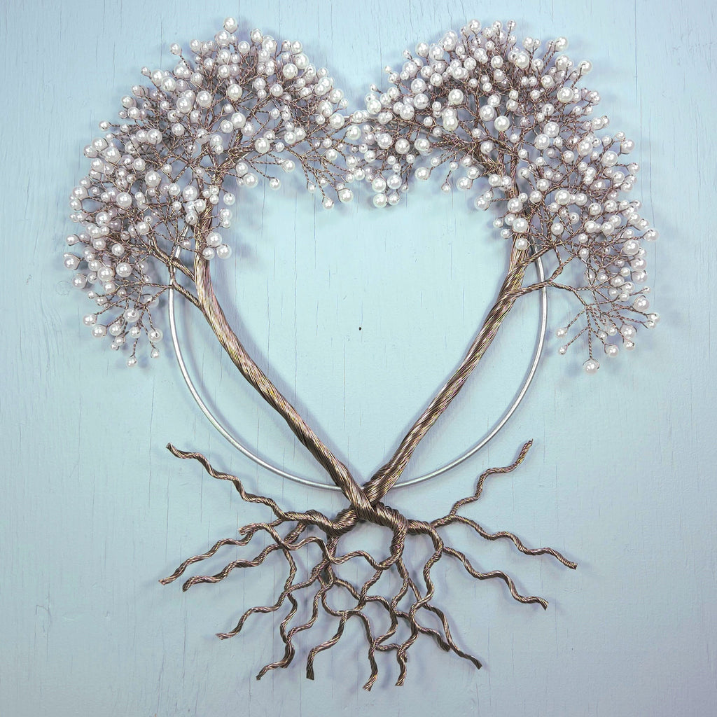 Decorative wall art of a tree with heart-shaped branches on a light blue background