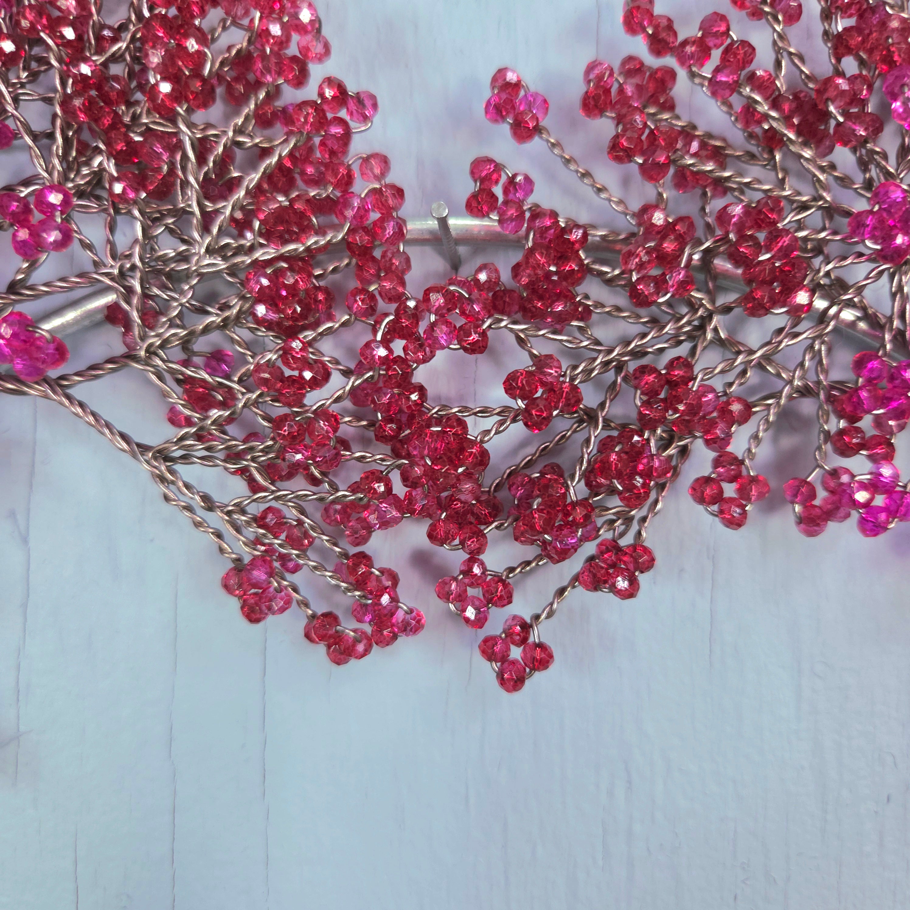 Pink beaded branches on a light blue background