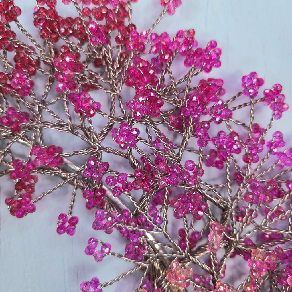 Decorative branch with pink beads on a light background