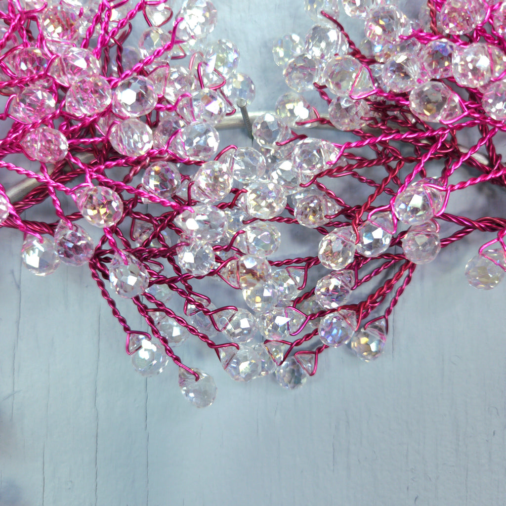 Decorative string with pink and clear beads on a light gray background