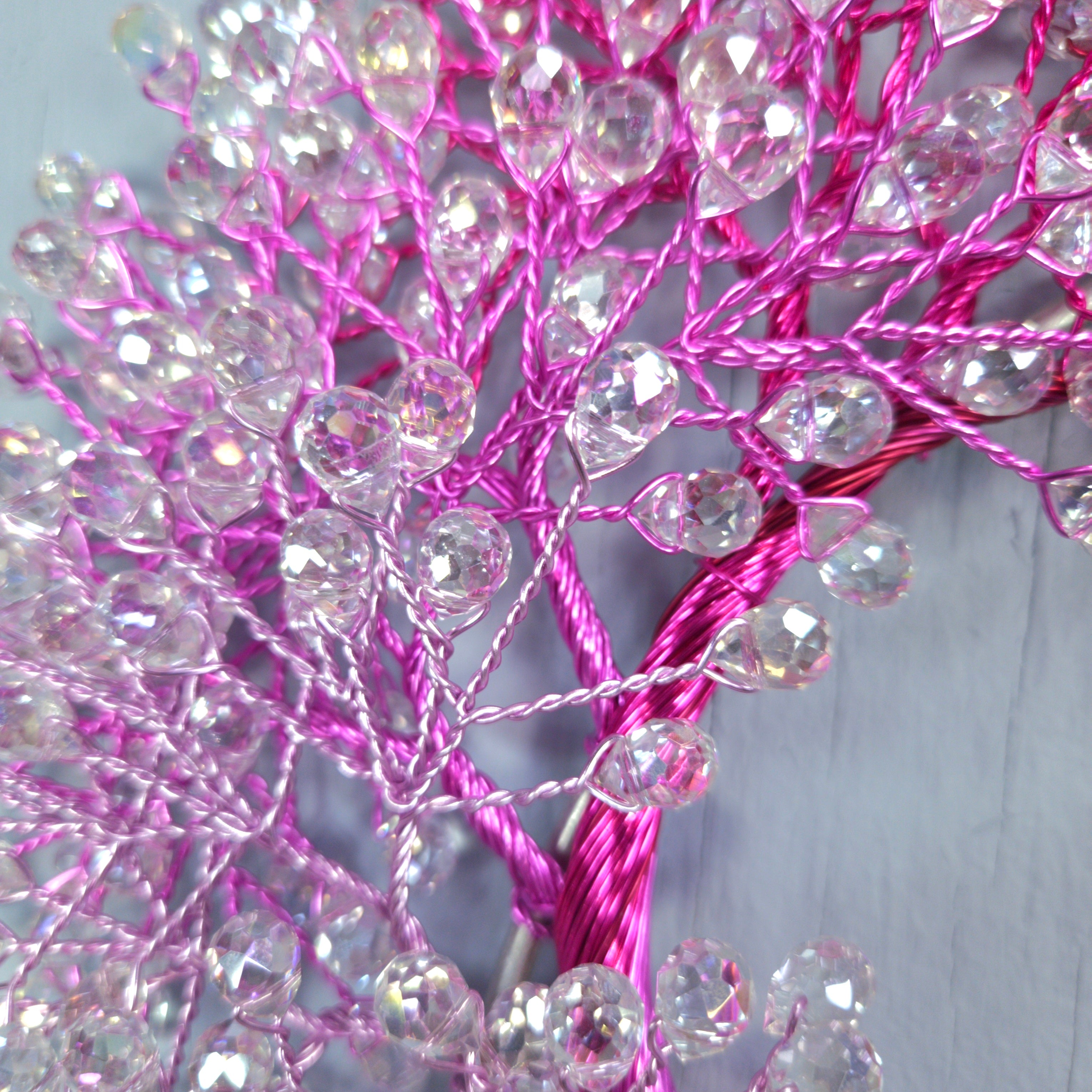Decorative branch with pink and silver beads on a light gray background