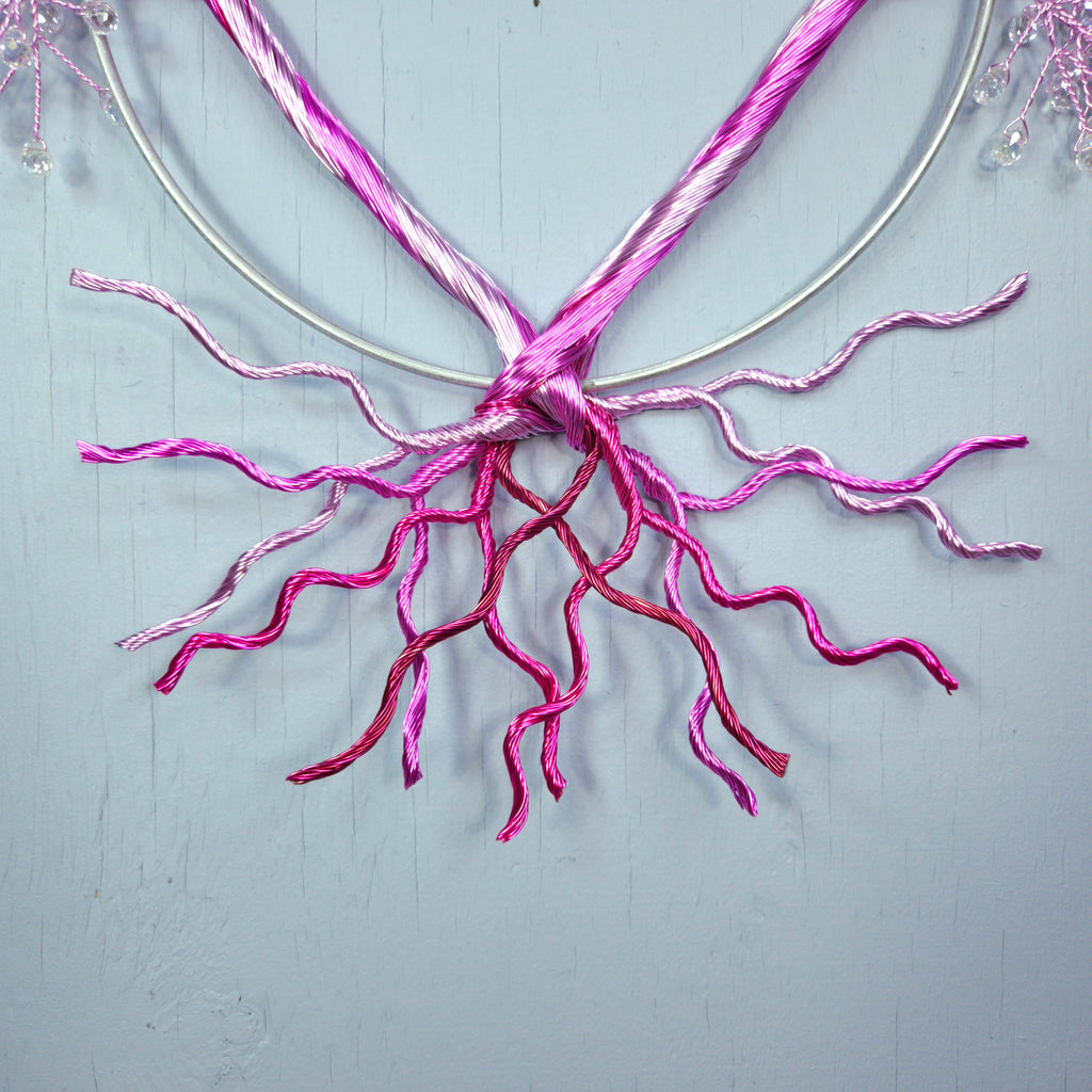 Pink decorative branches tied together on a light blue background