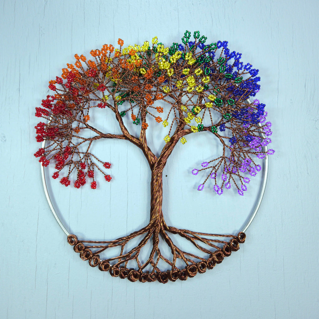 Colorful beaded tree of life wall art on a light blue background