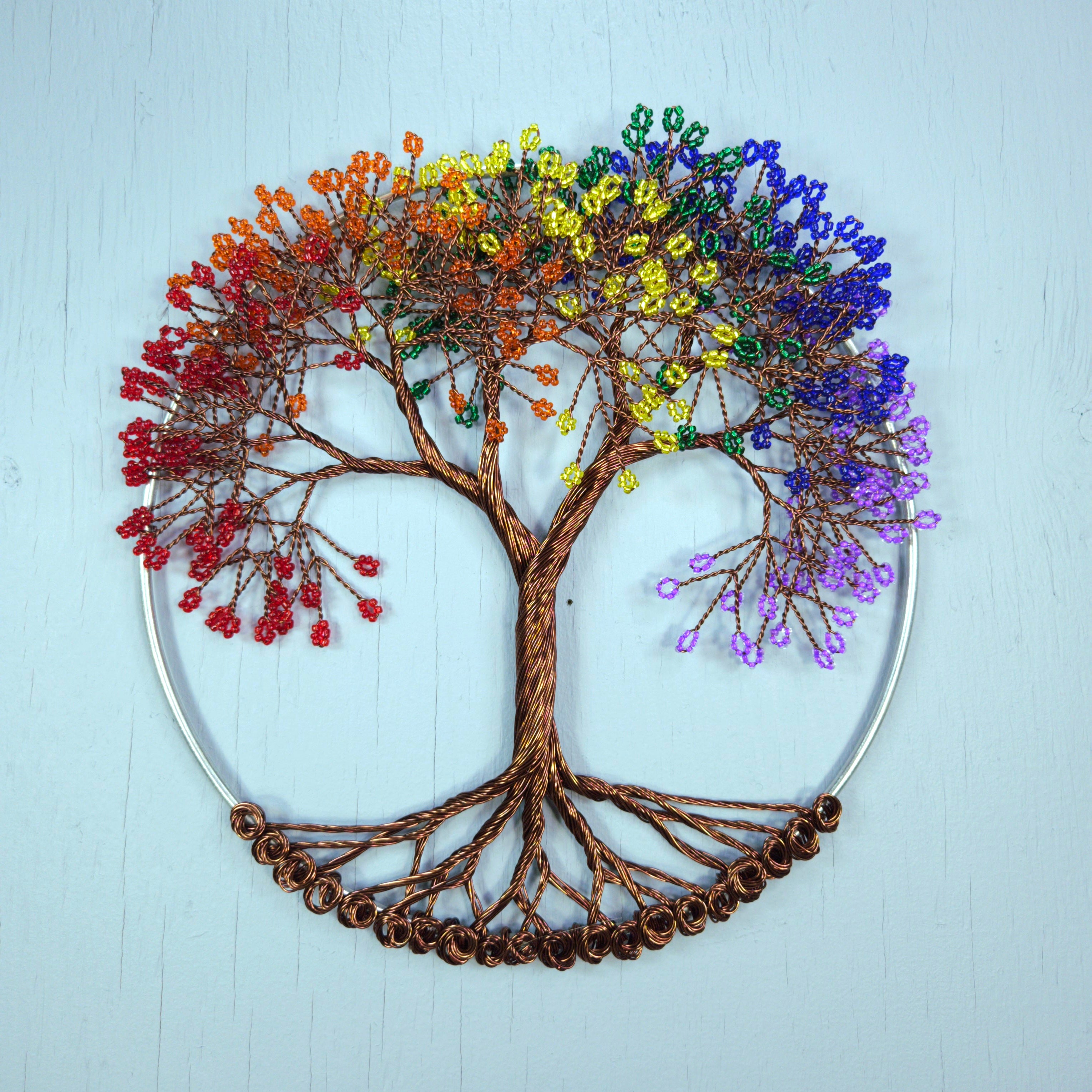 Colorful beaded tree of life wall art on a light blue background