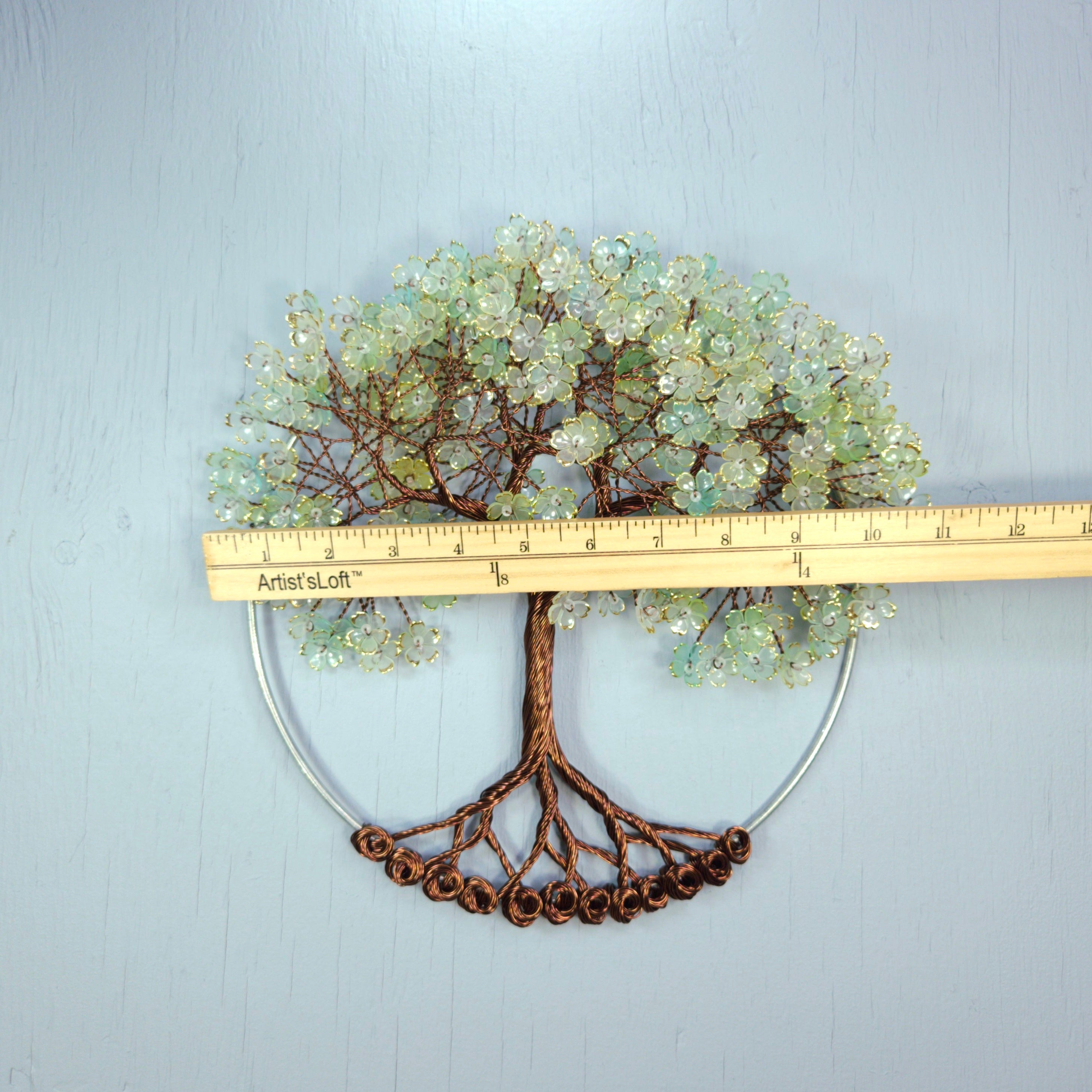 Decorative tree wall art with a ruler for scale on a light gray background