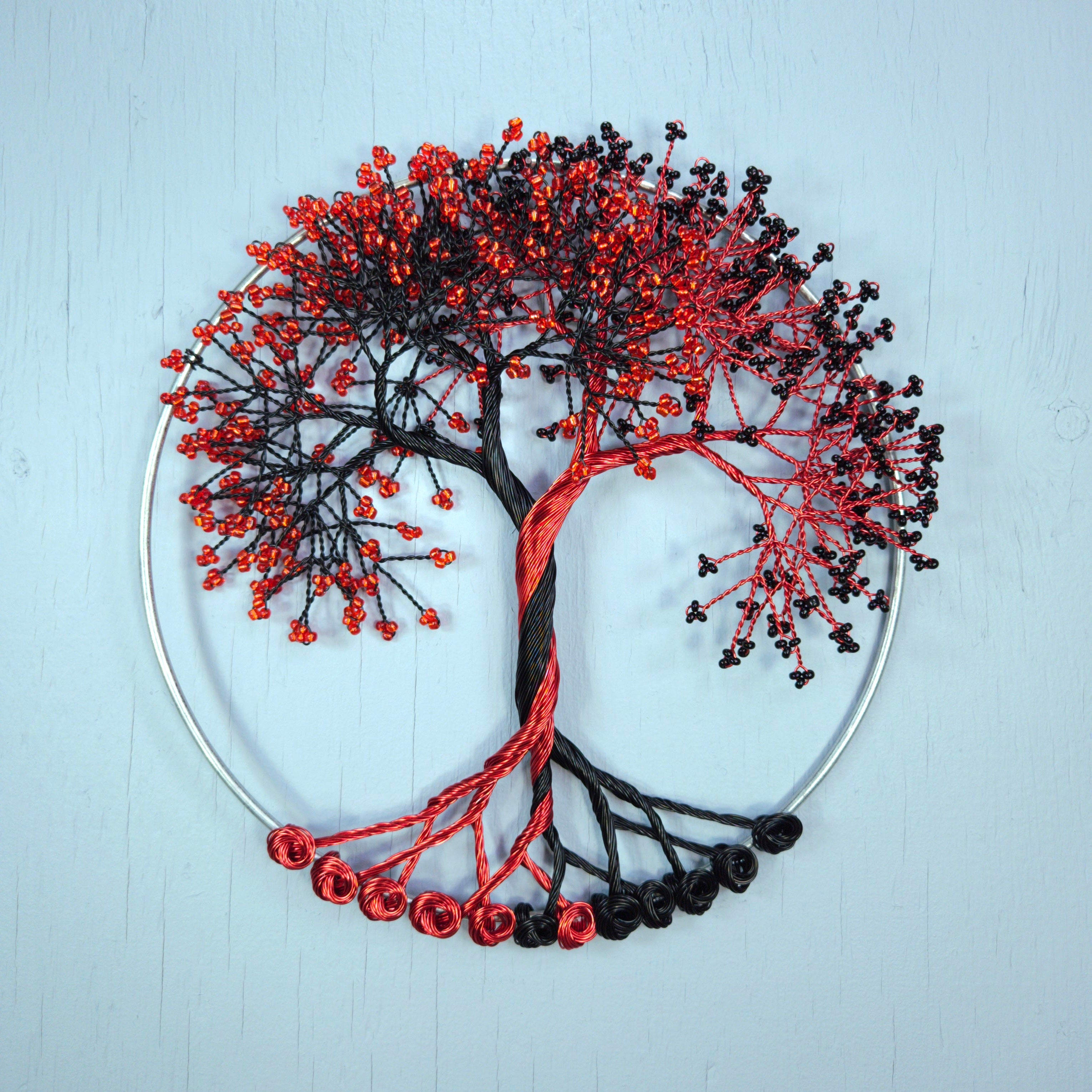 Decorative tree of life with red and black branches on a light blue background