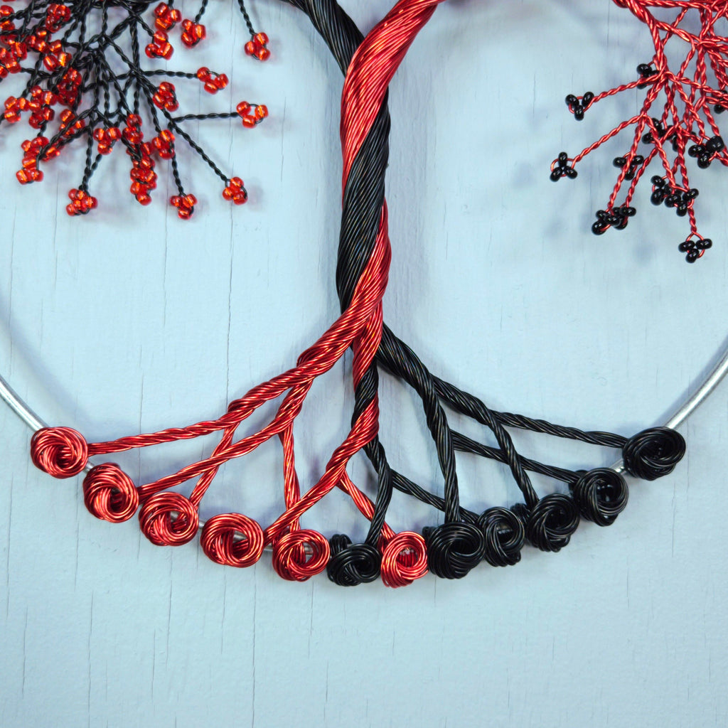 Black and red beaded necklaces on a light blue fabric background
