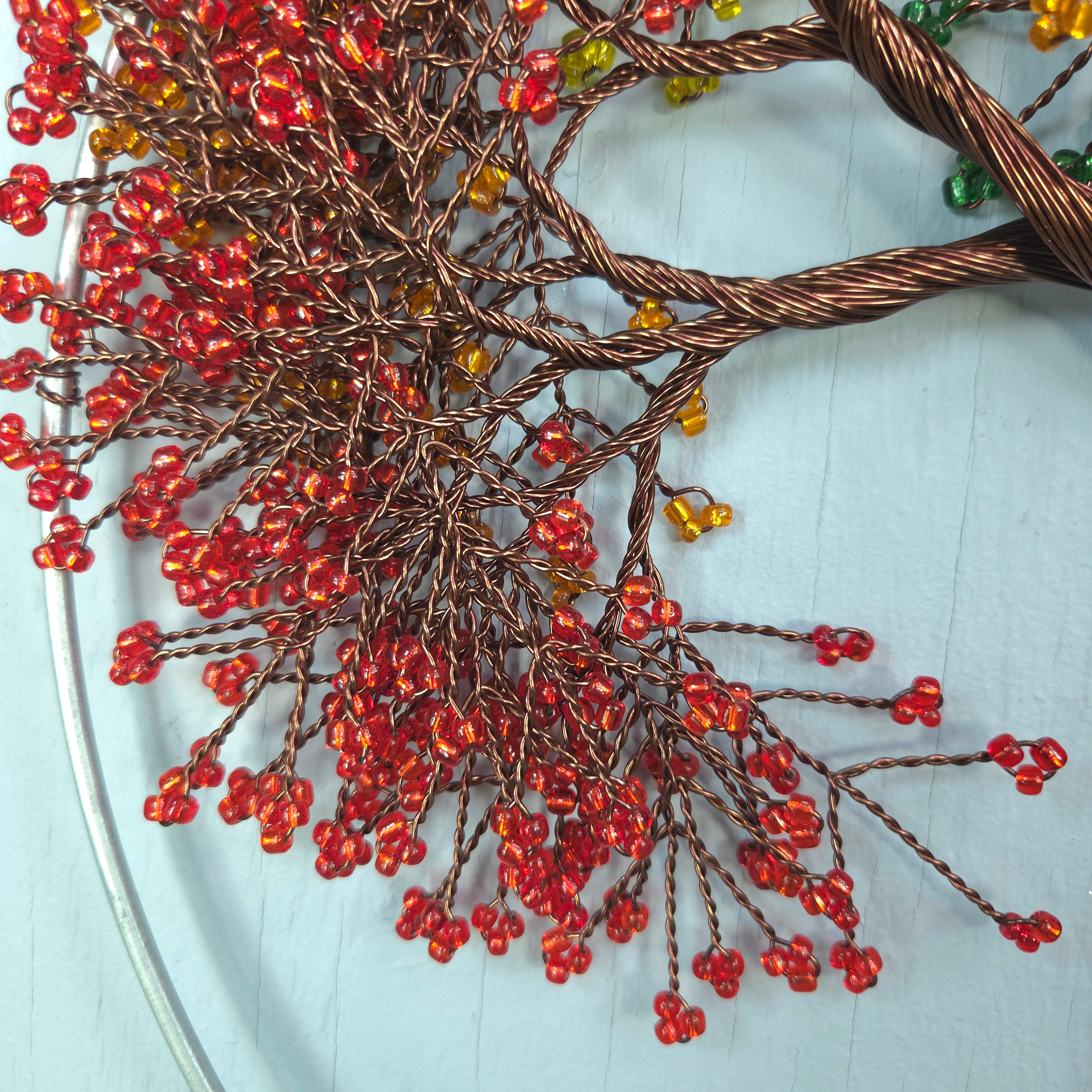 Decorative wreath with red berries and copper wire on a light blue background