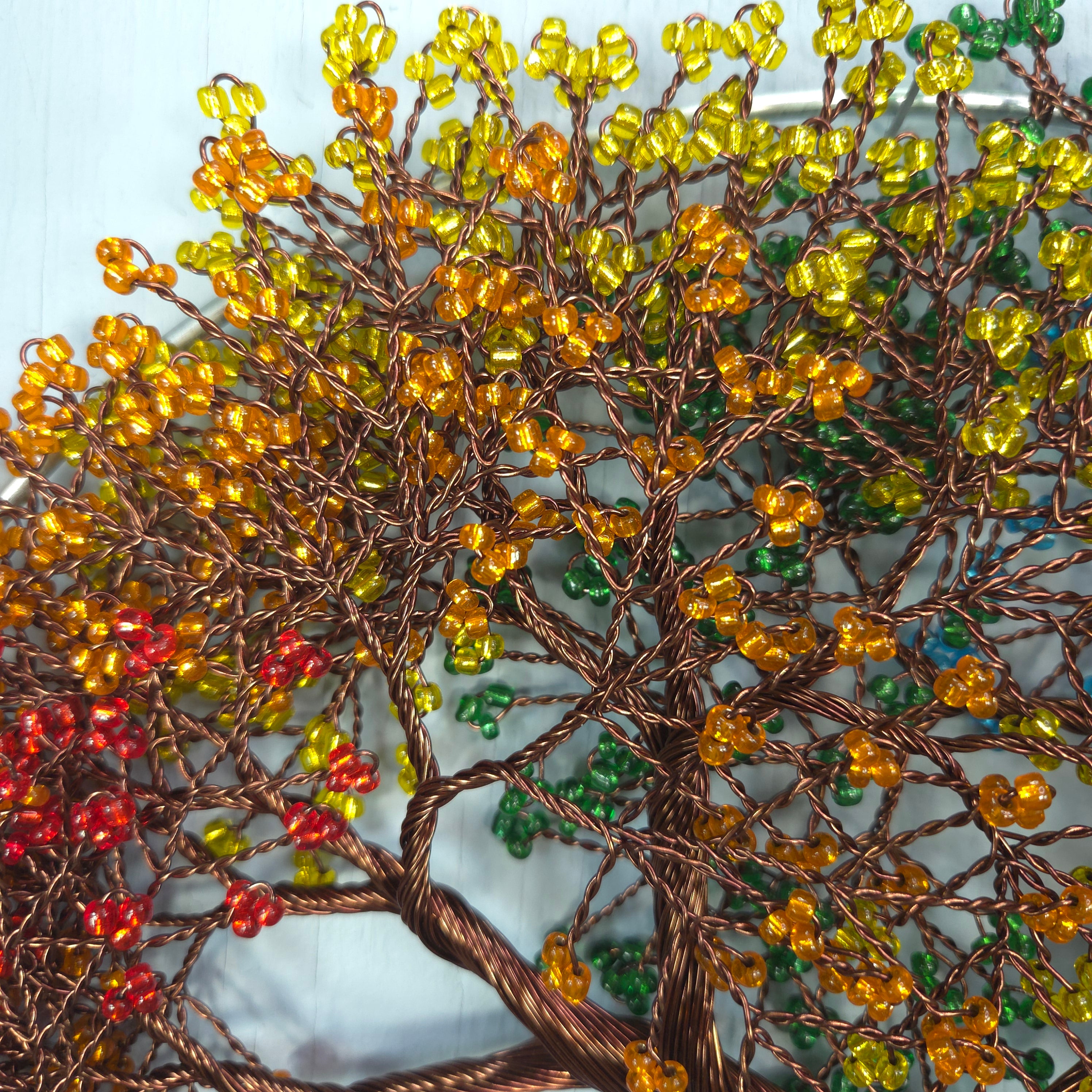 Close-up of a beaded tree with autumn colors on a white background