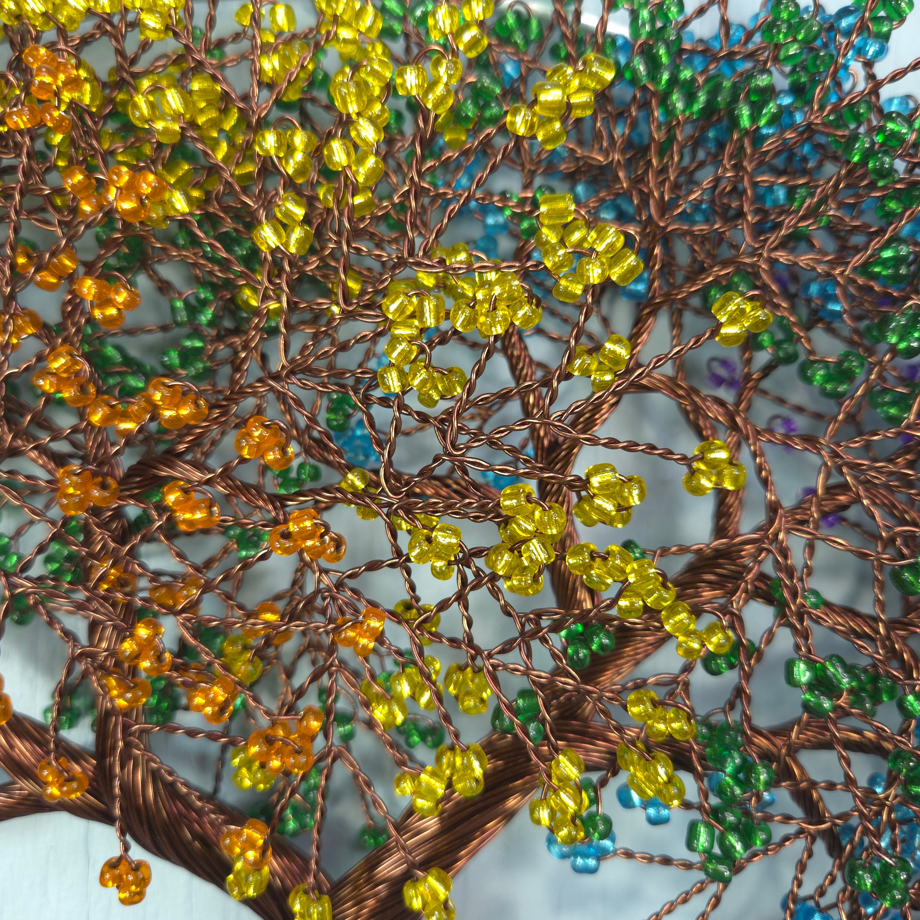 Close-up of intricate beadwork with yellow beads on a white background