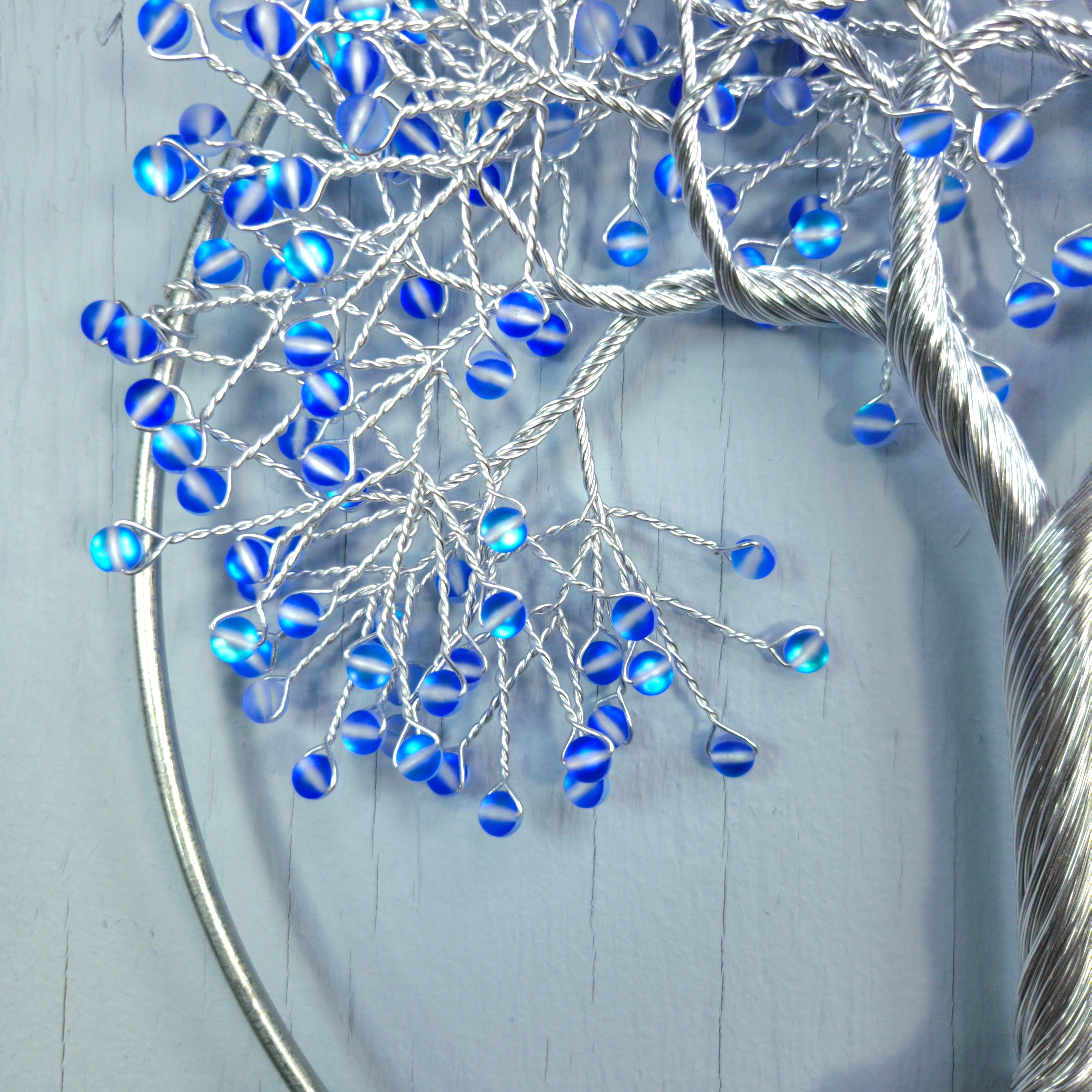 Decorative branch with blue beads on a light gray background