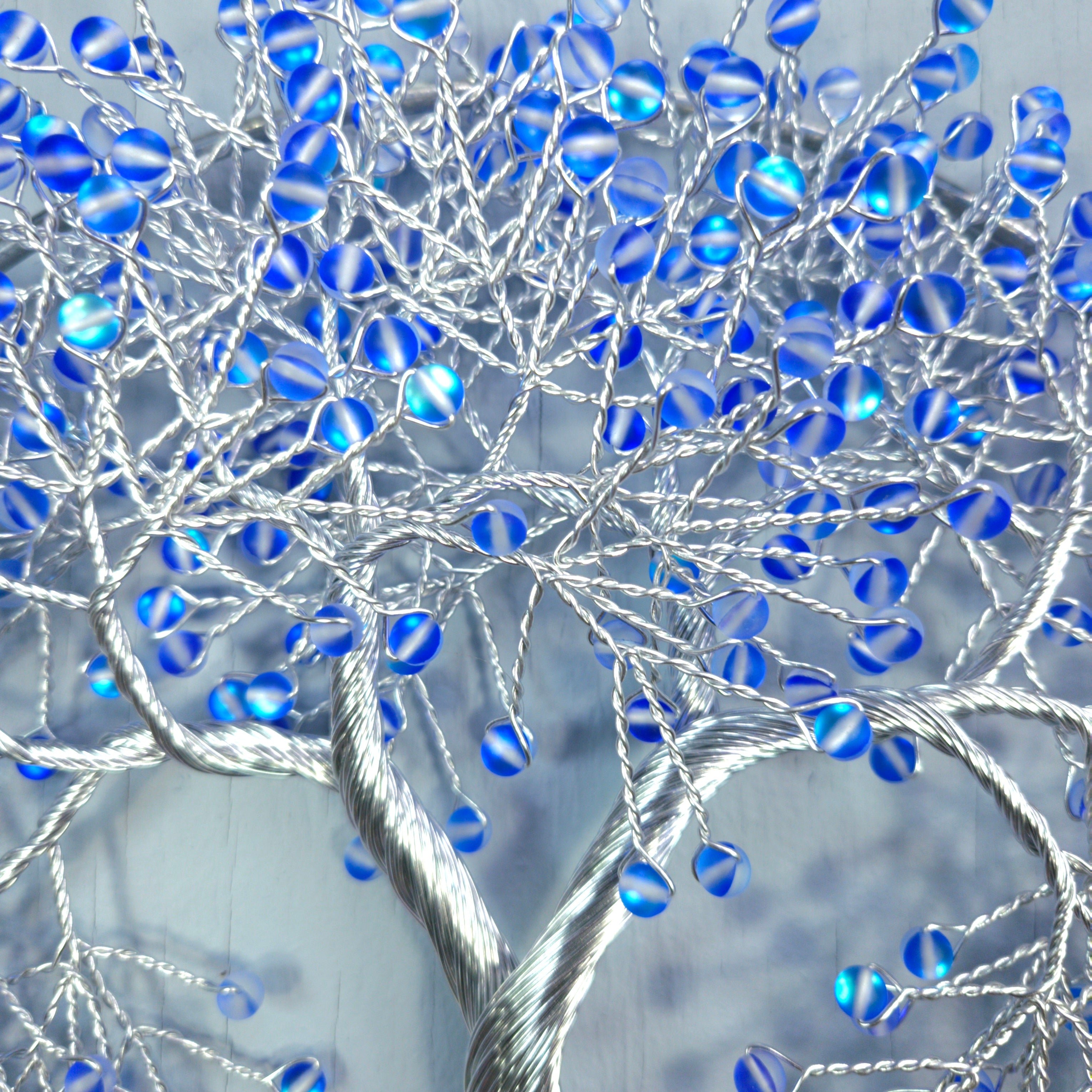 Decorative tree with blue beads on a gray background
