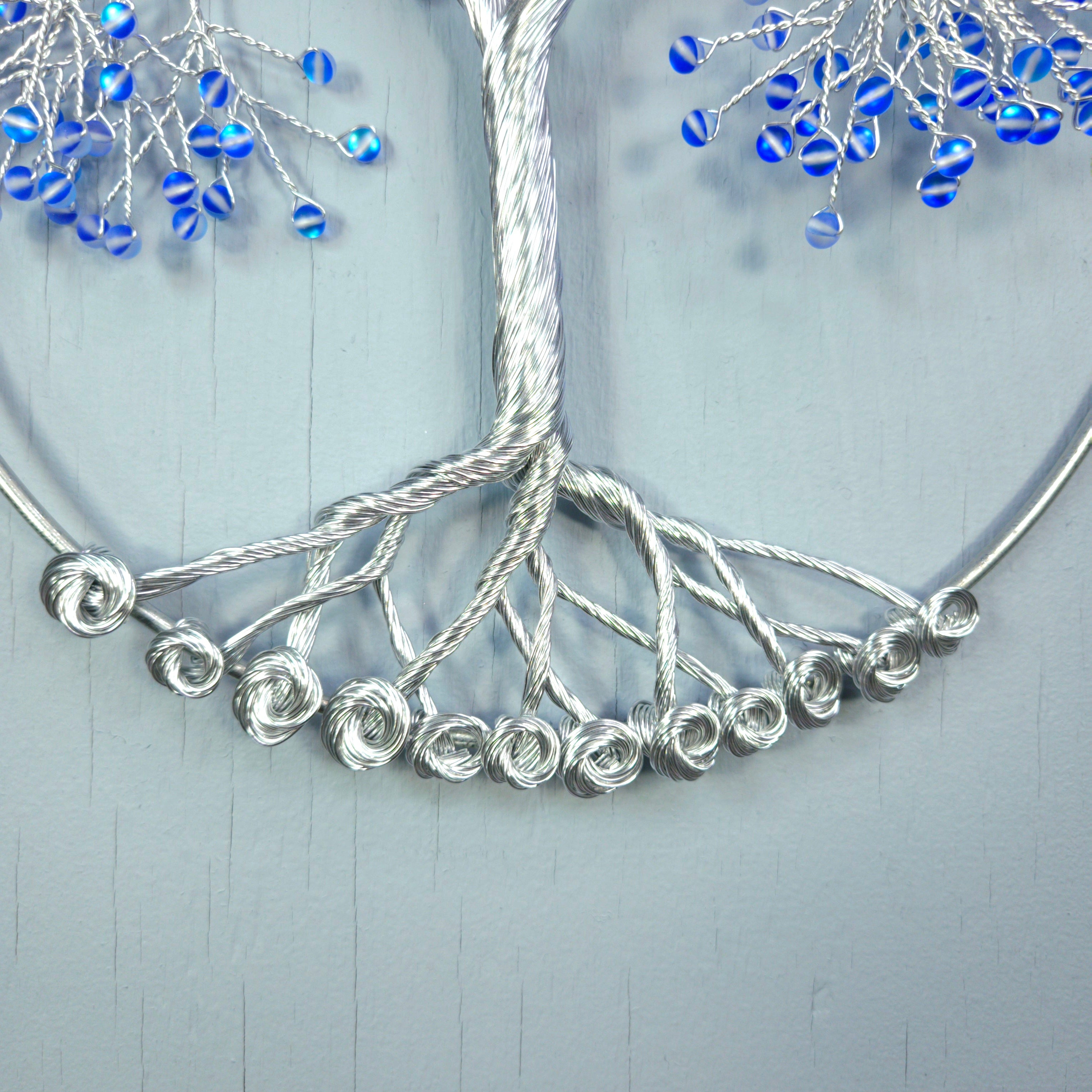 Silver necklace with blue beads on a light gray background