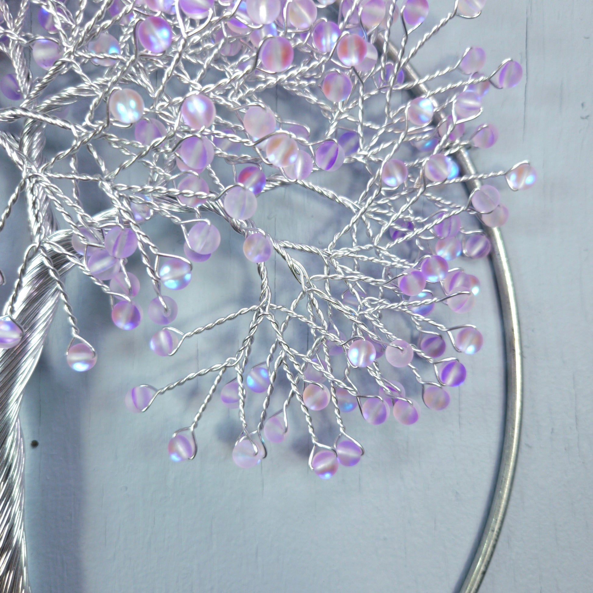 Decorative branch with purple beads on a light gray background