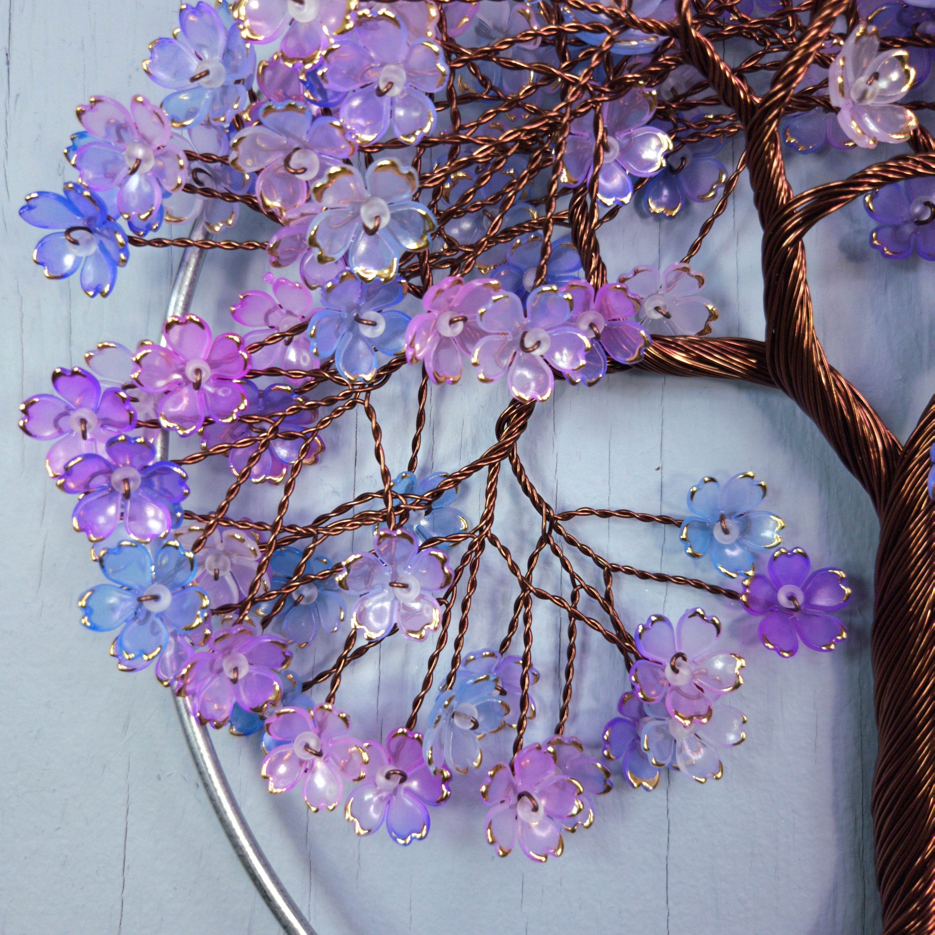 Decorative wall art with purple and blue flowers on a light blue background