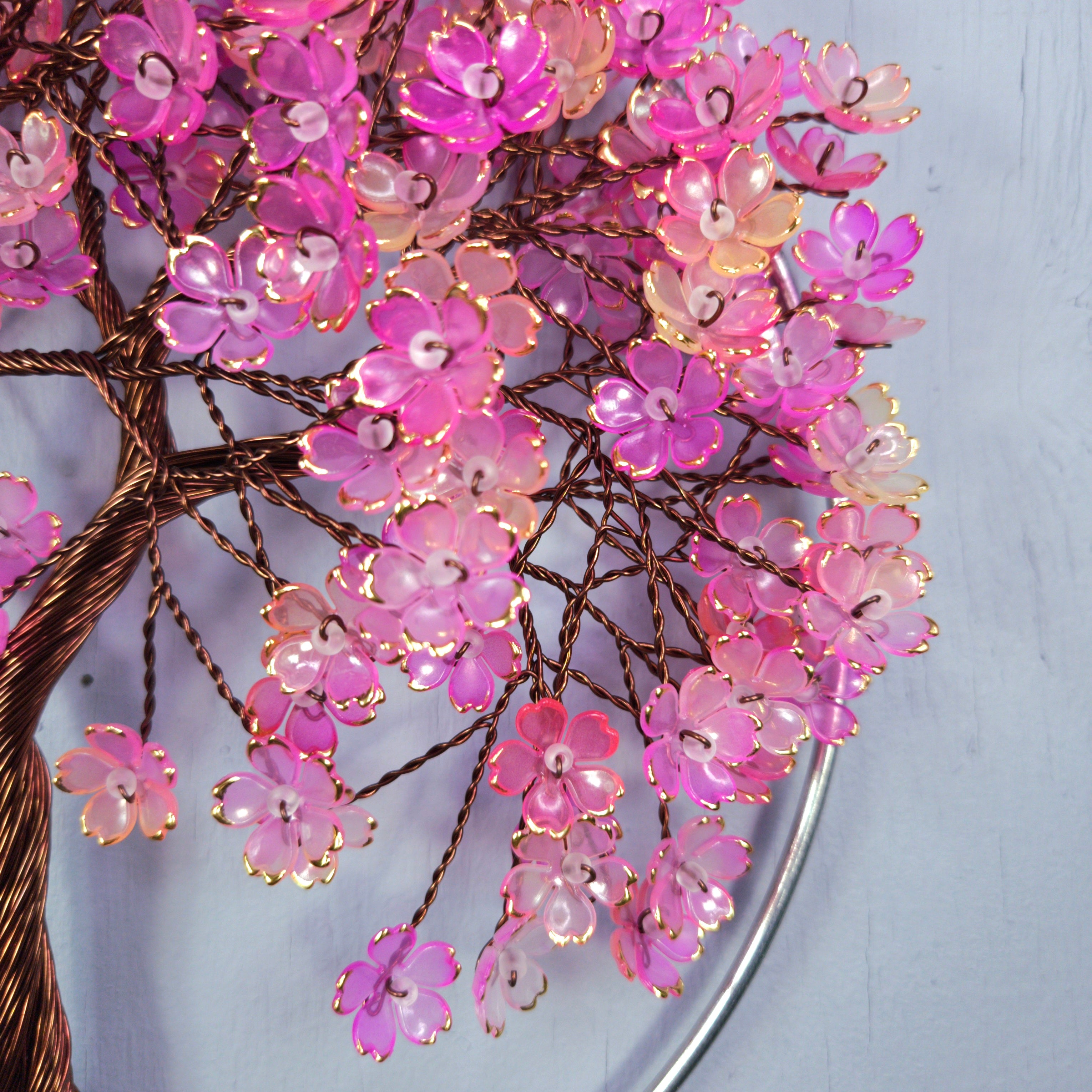 Decorative wall art with pink floral branches on a light blue background