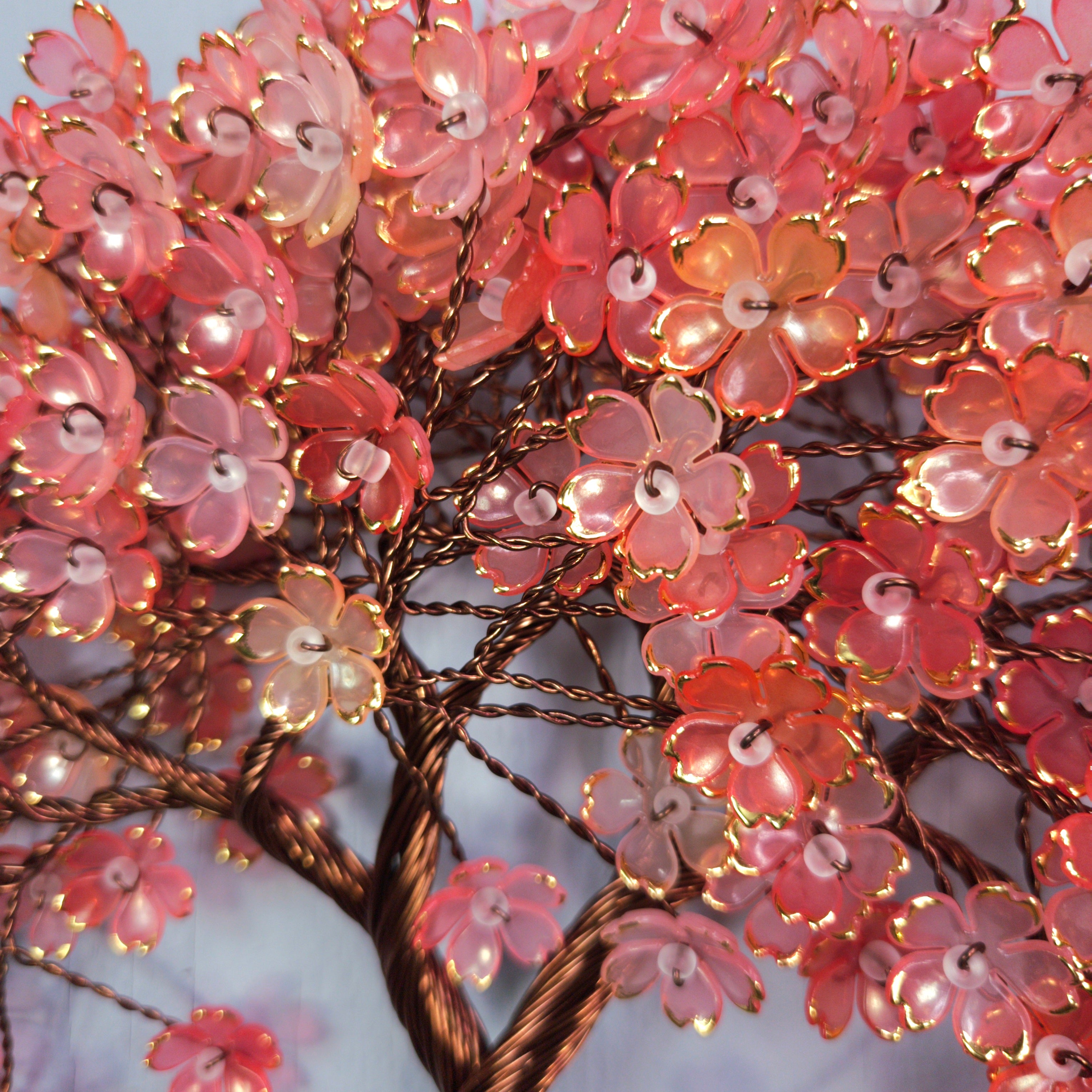 Decorative floral light fixture with pink flowers and string lights on a white background