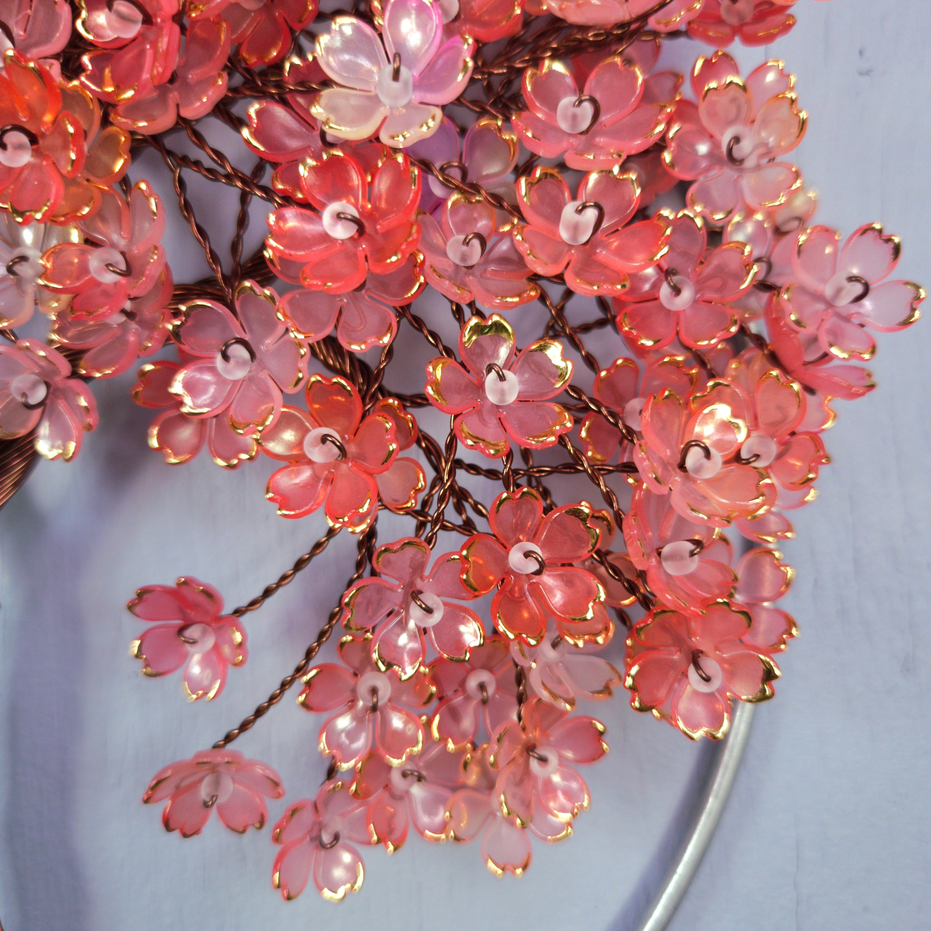 Decorative pink floral branch with lights on a light blue background