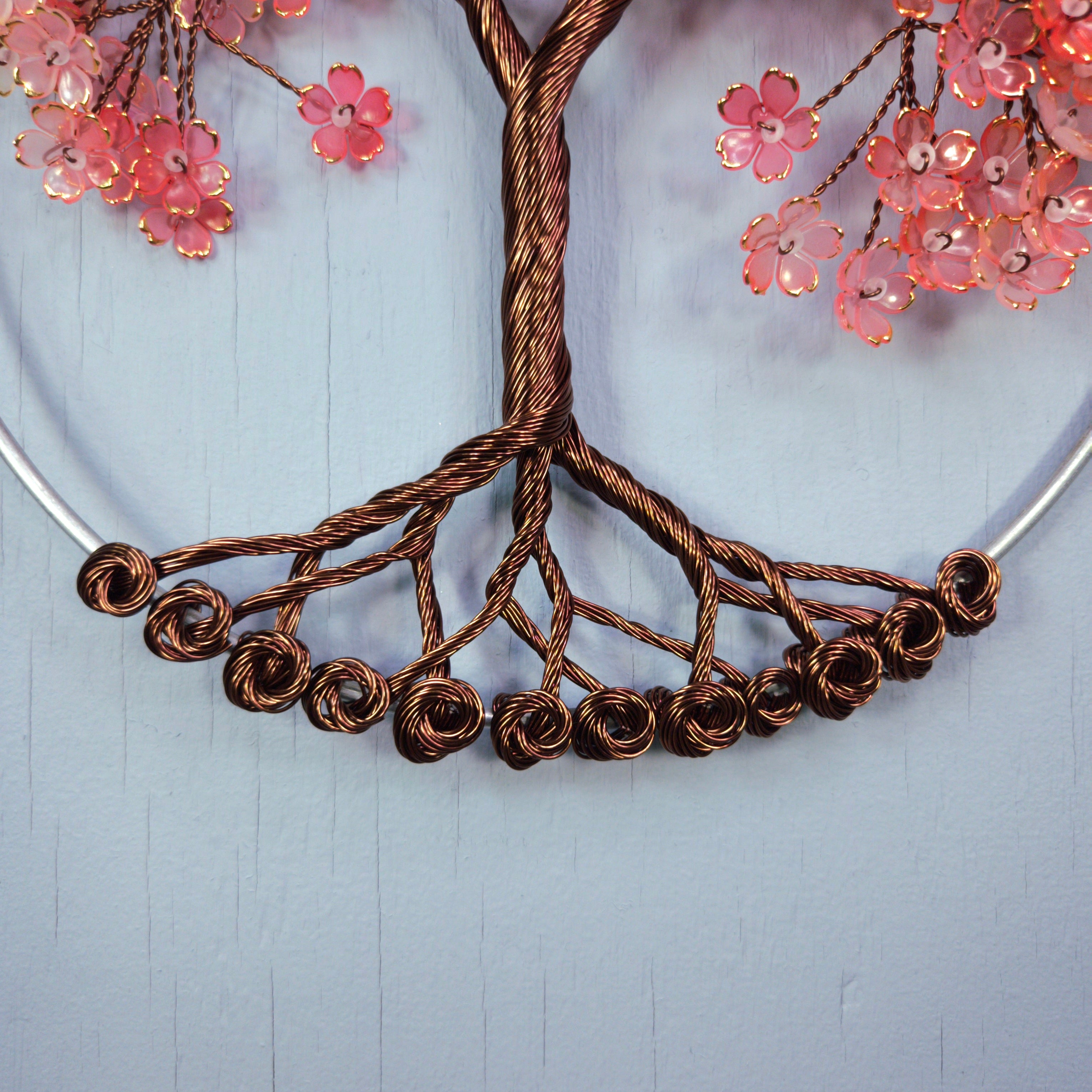 Copper necklace with floral elements on a light blue background