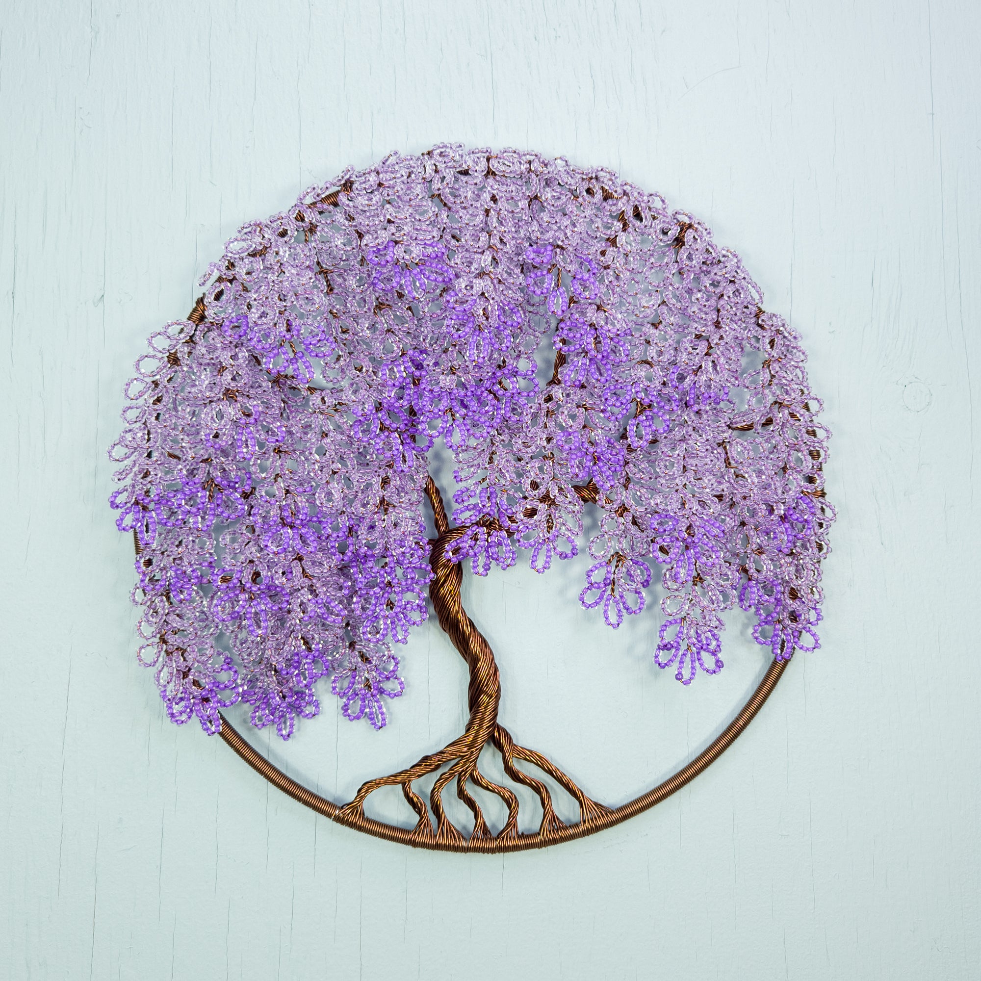 Decorative wall art of a purple flowering tree on a light blue background