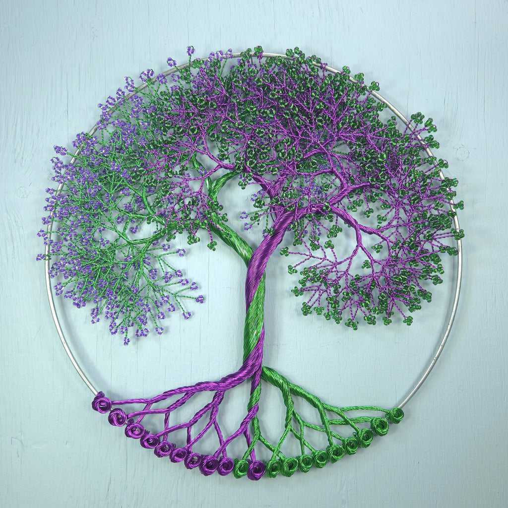 Decorative wall art of a tree with purple and green branches on a light blue background