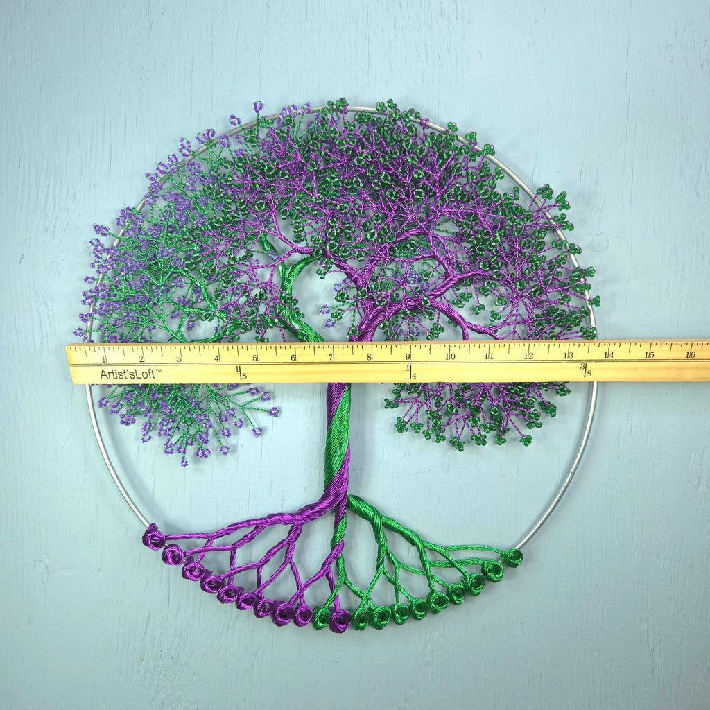 Embroidered tree design with a ruler for scale on a light blue background