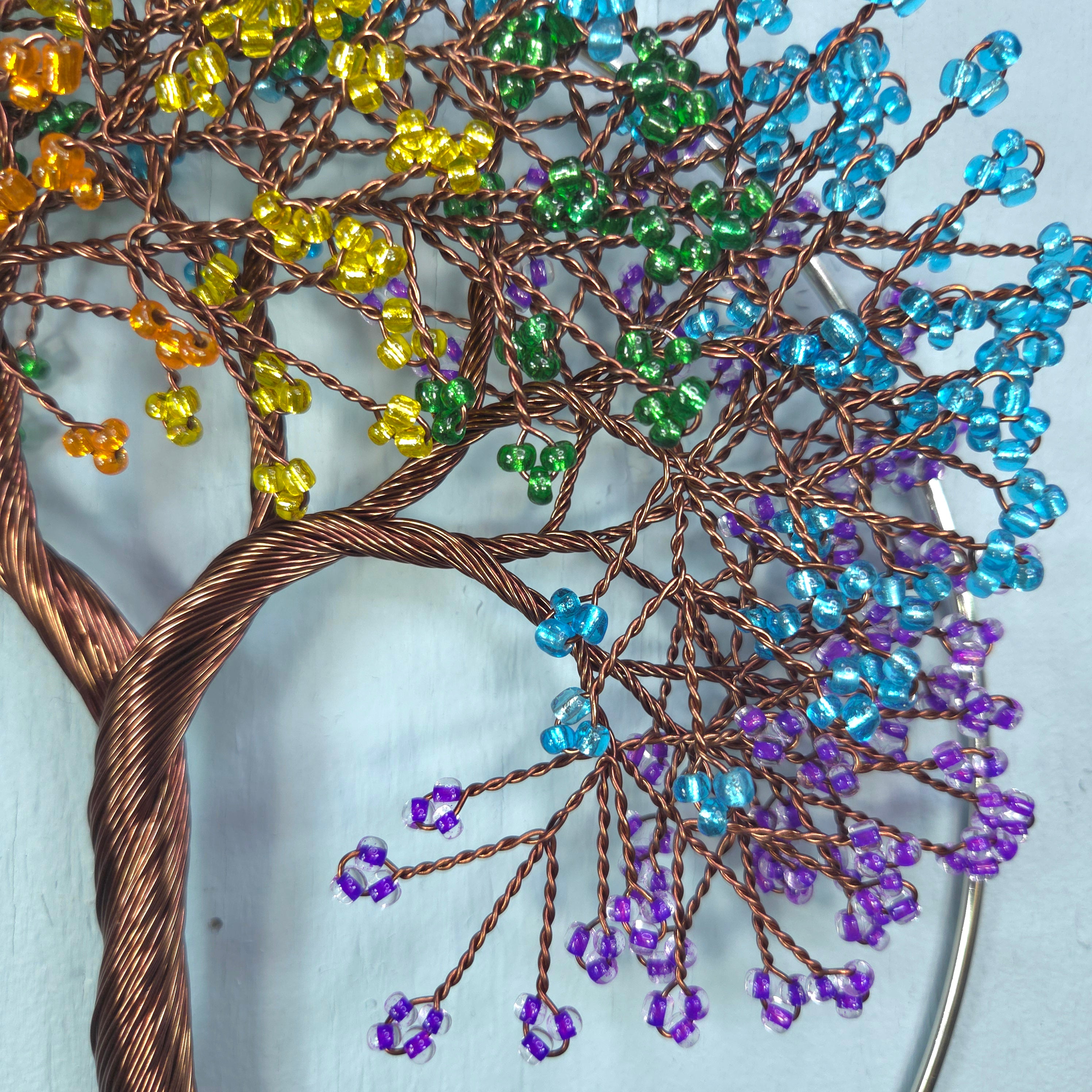 Decorative tree sculpture with multicolored beads on a white background