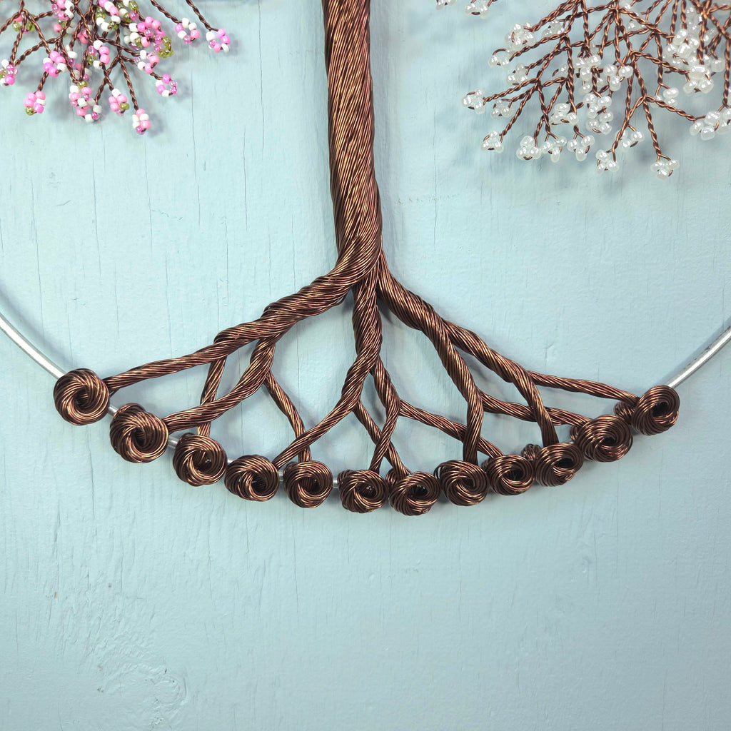 Necklace with brown wire tree design against a light blue background