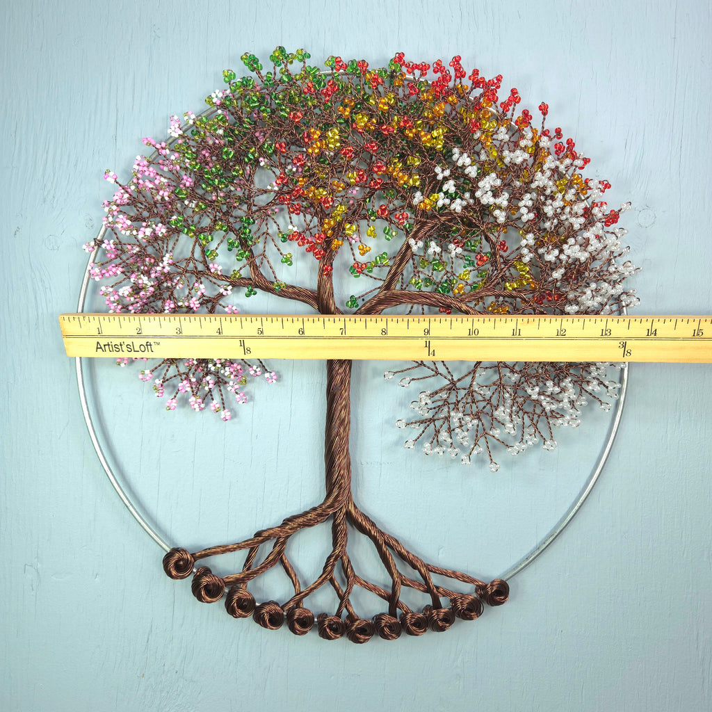 Decorative wall art of a tree with colorful branches on a light blue background, featuring a ruler for scale.