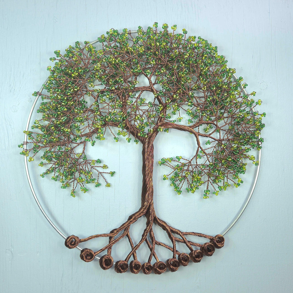Decorative wall art of a tree with green leaves on a light blue background