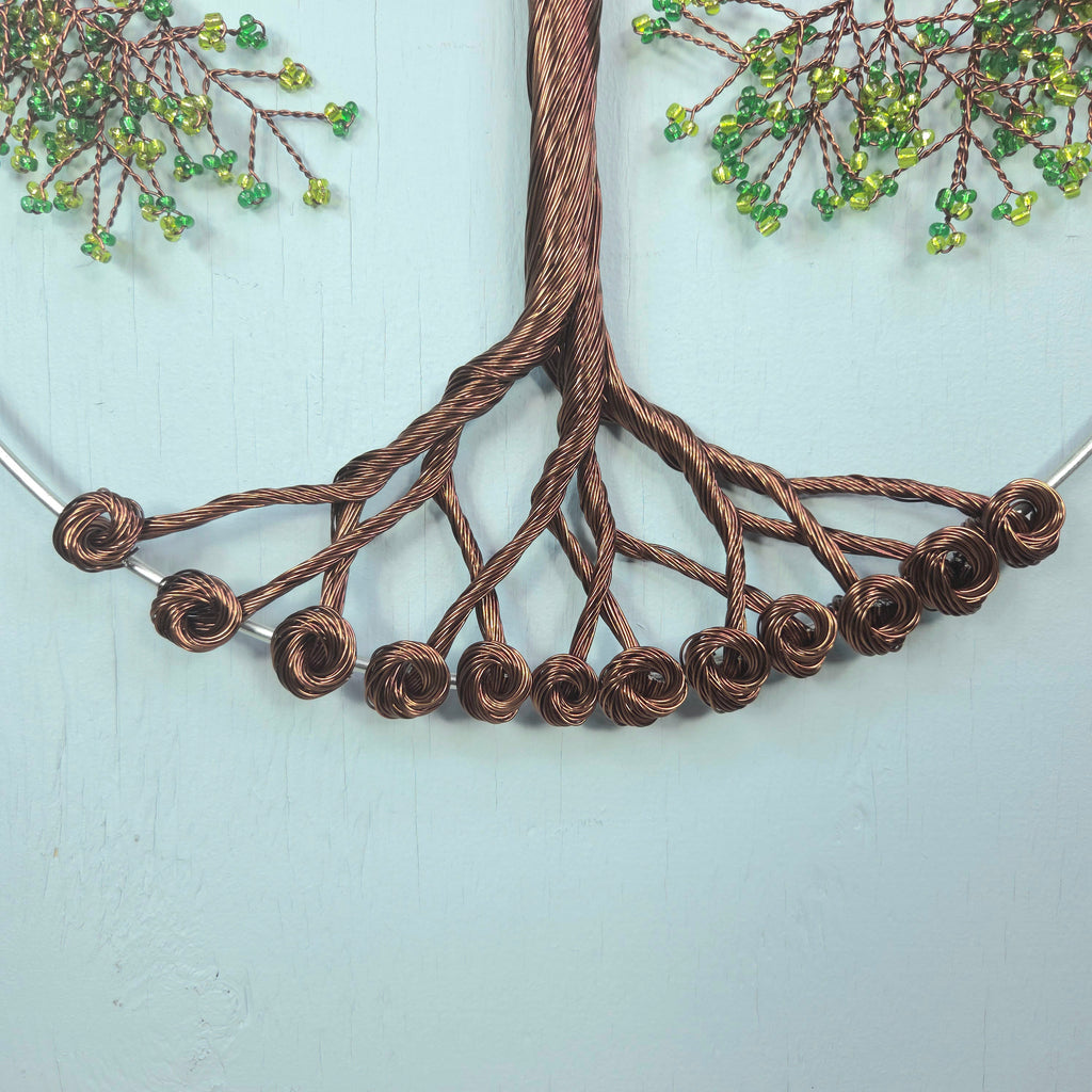 Decorative wall art with braided wire tree design on a light blue background