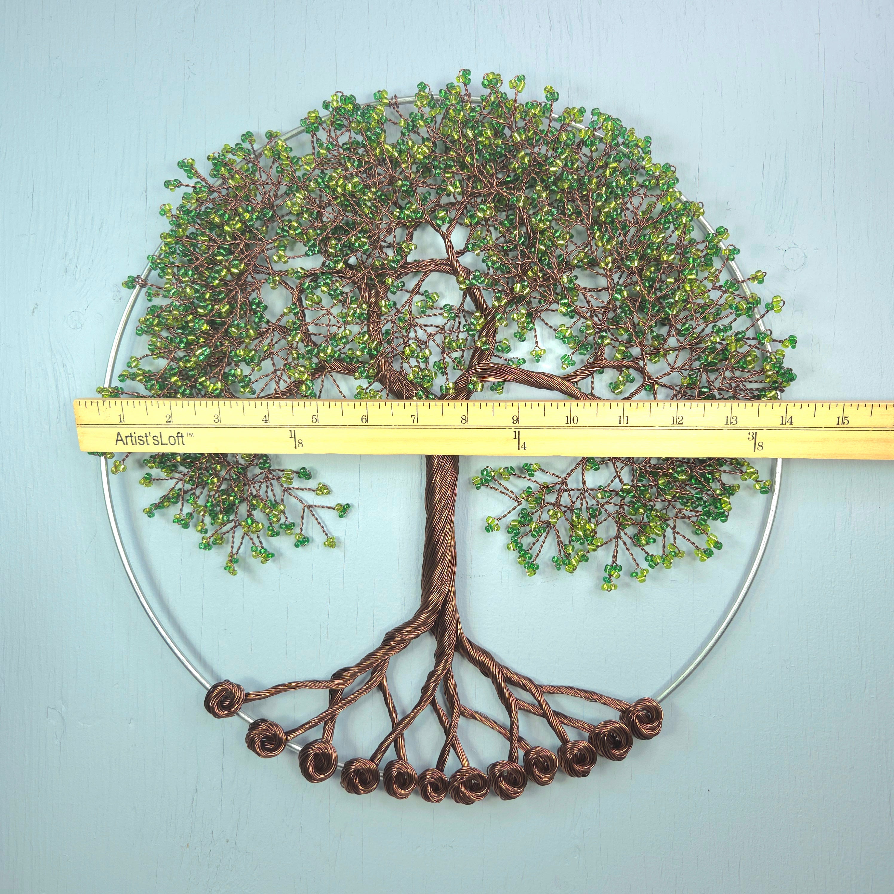 Decorative wall art of a tree with a ruler for scale on a light blue background