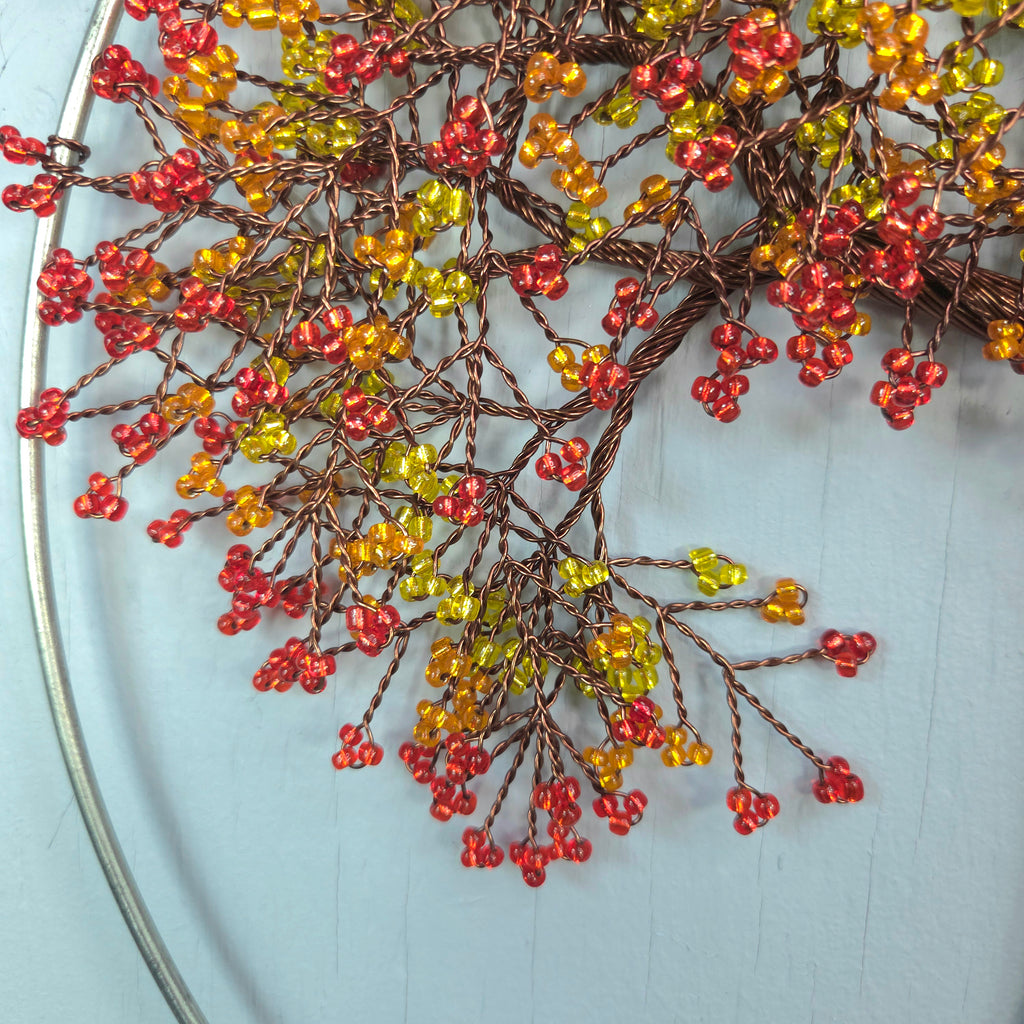 Decorative wreath with red and yellow berries on a light blue background